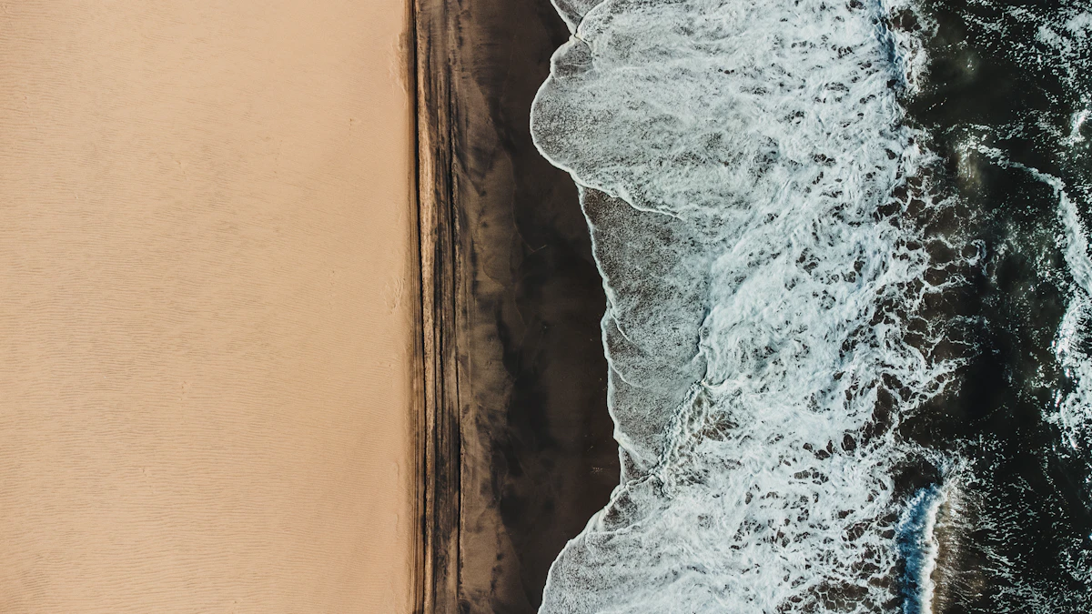 Aerial view of ocean waves crashing on a sandy beach. Photo by NIR HIMI on Unsplash
