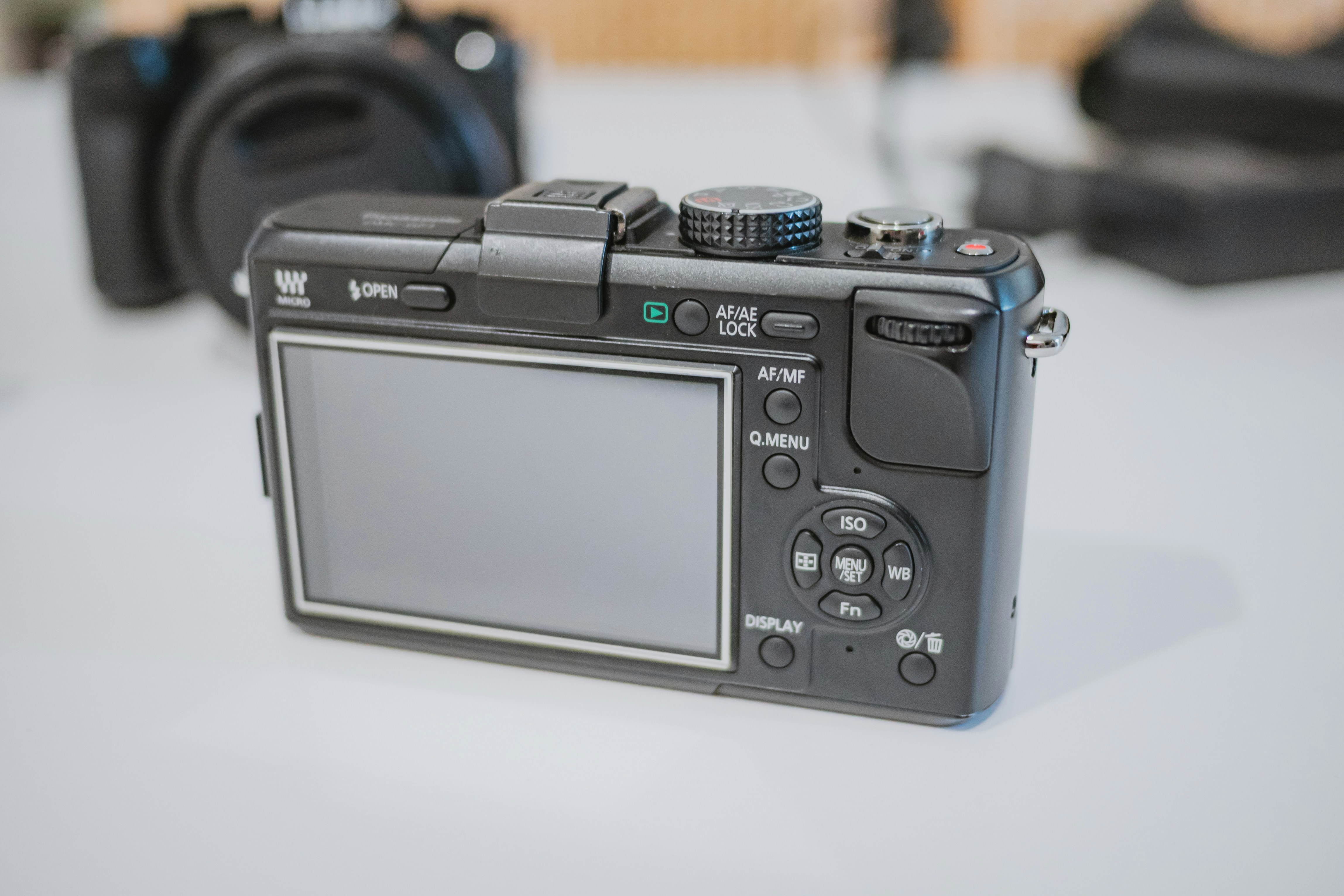 Rear view of a black digital camera with screen.