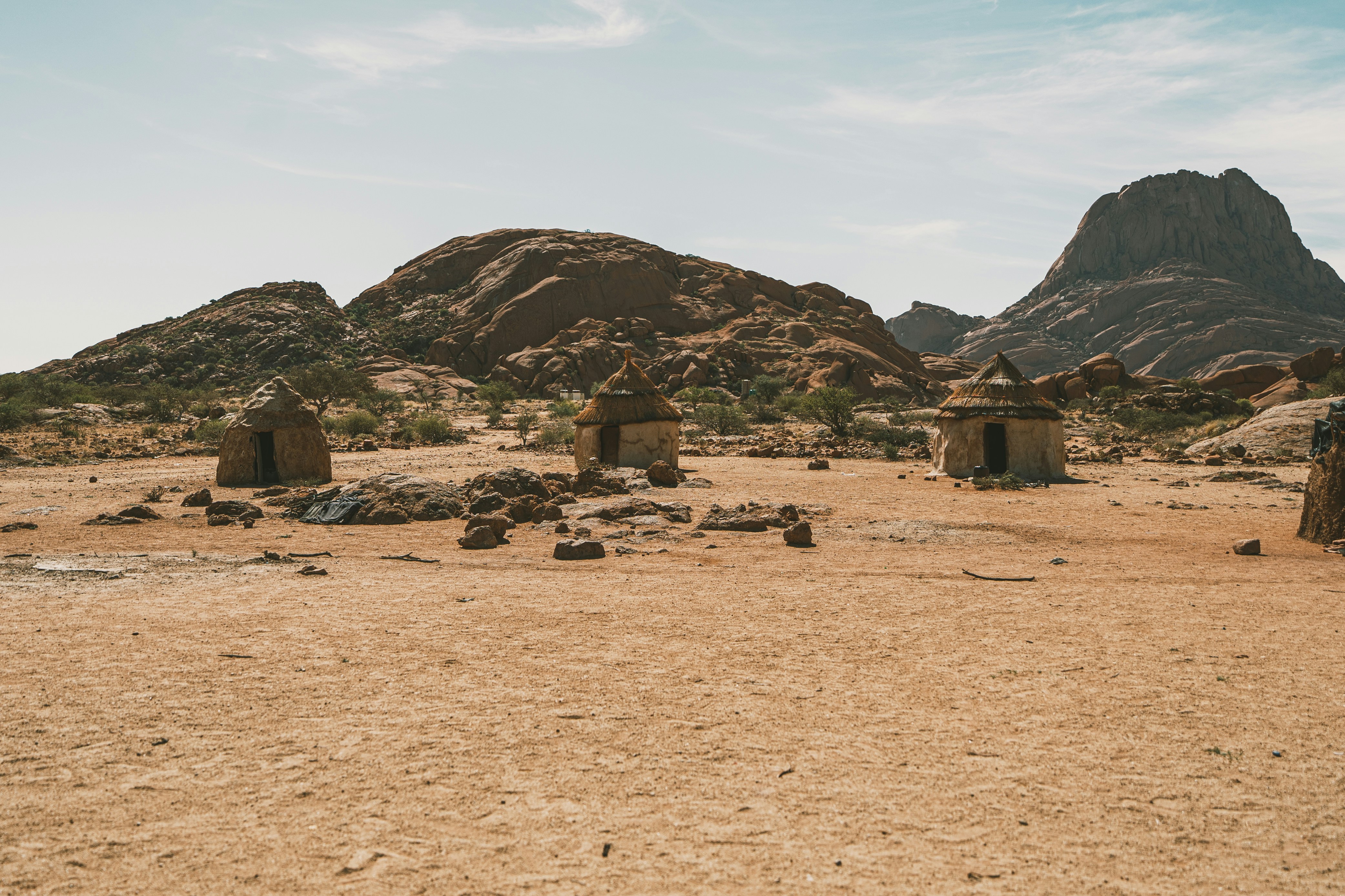Small stone huts in a dry, rocky landscape.