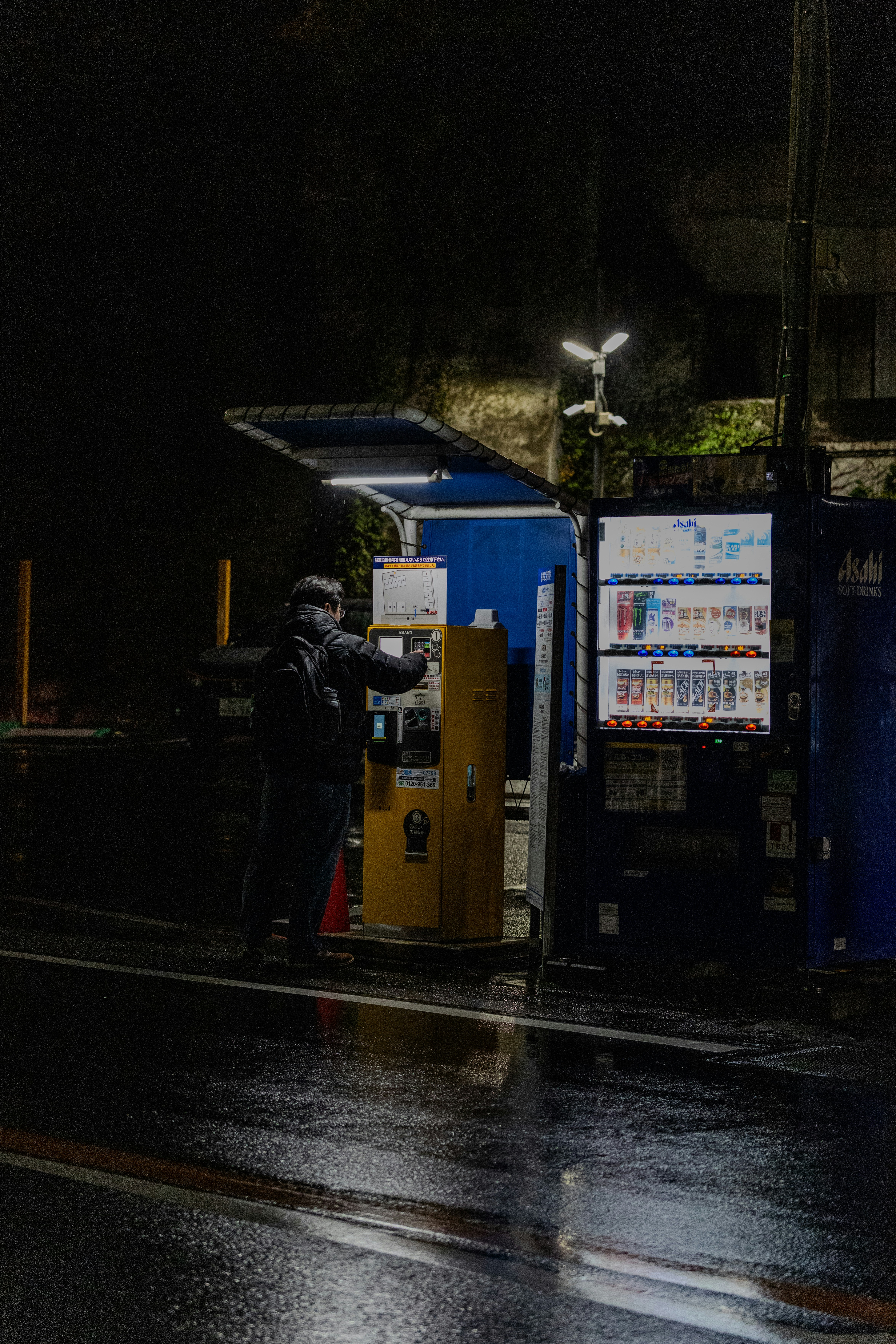 Man using a vending machine at night