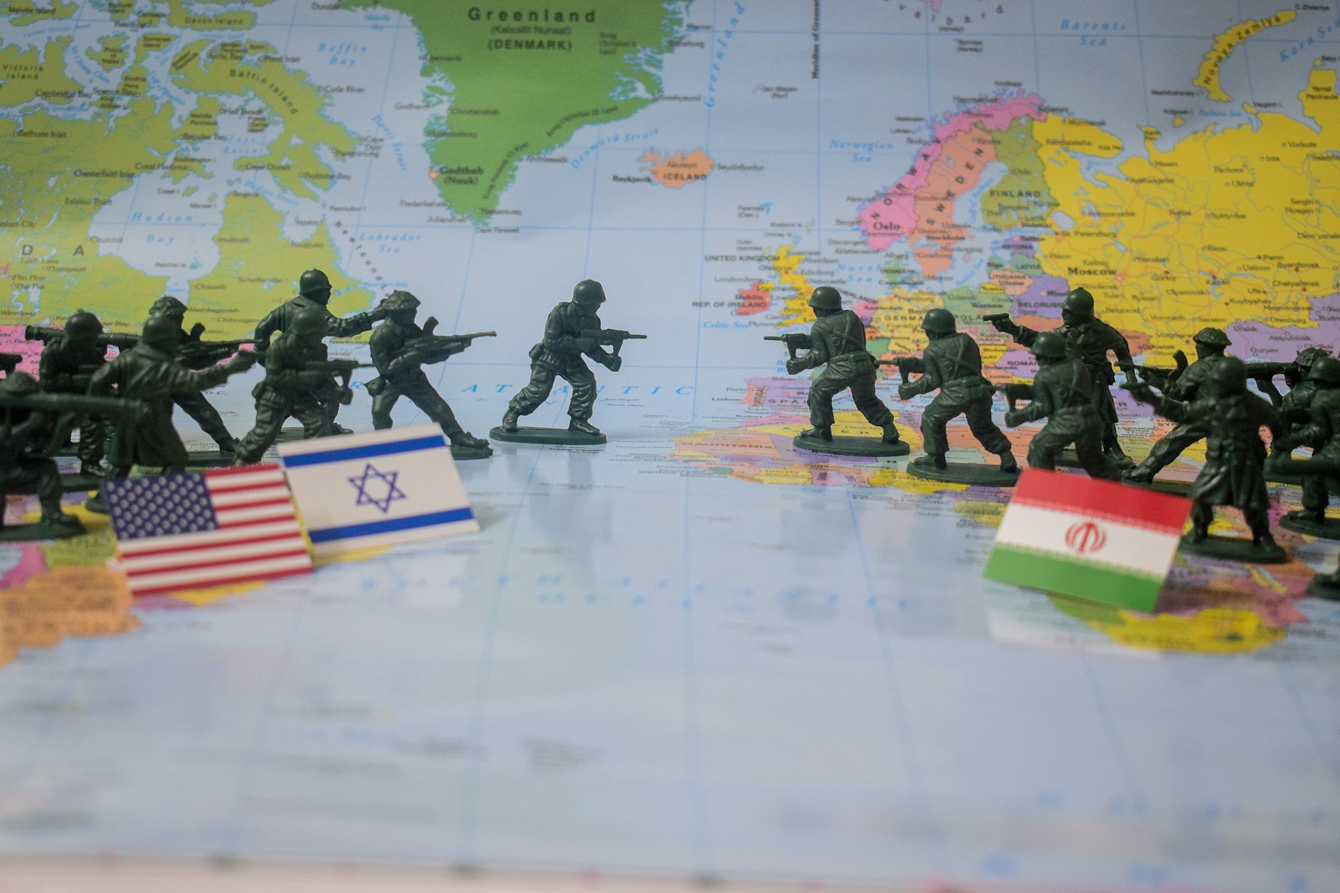 Toy soldiers face off on world map with flags.