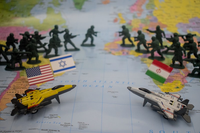 Toy soldiers and jets arranged on a world map with US and Iran flags