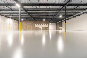Spacious empty warehouse interior with polished concrete floor.
