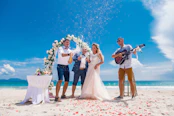Couple celebrating wedding with champagne on a beach