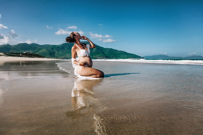 ibu hamil menikmati babymoon di pantai sebagai bagian dari tips traveling aman untuk ibu hamil