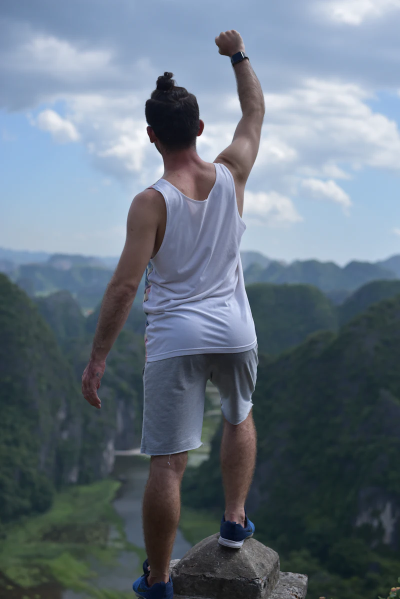 Person standing tall on a mountain ridge