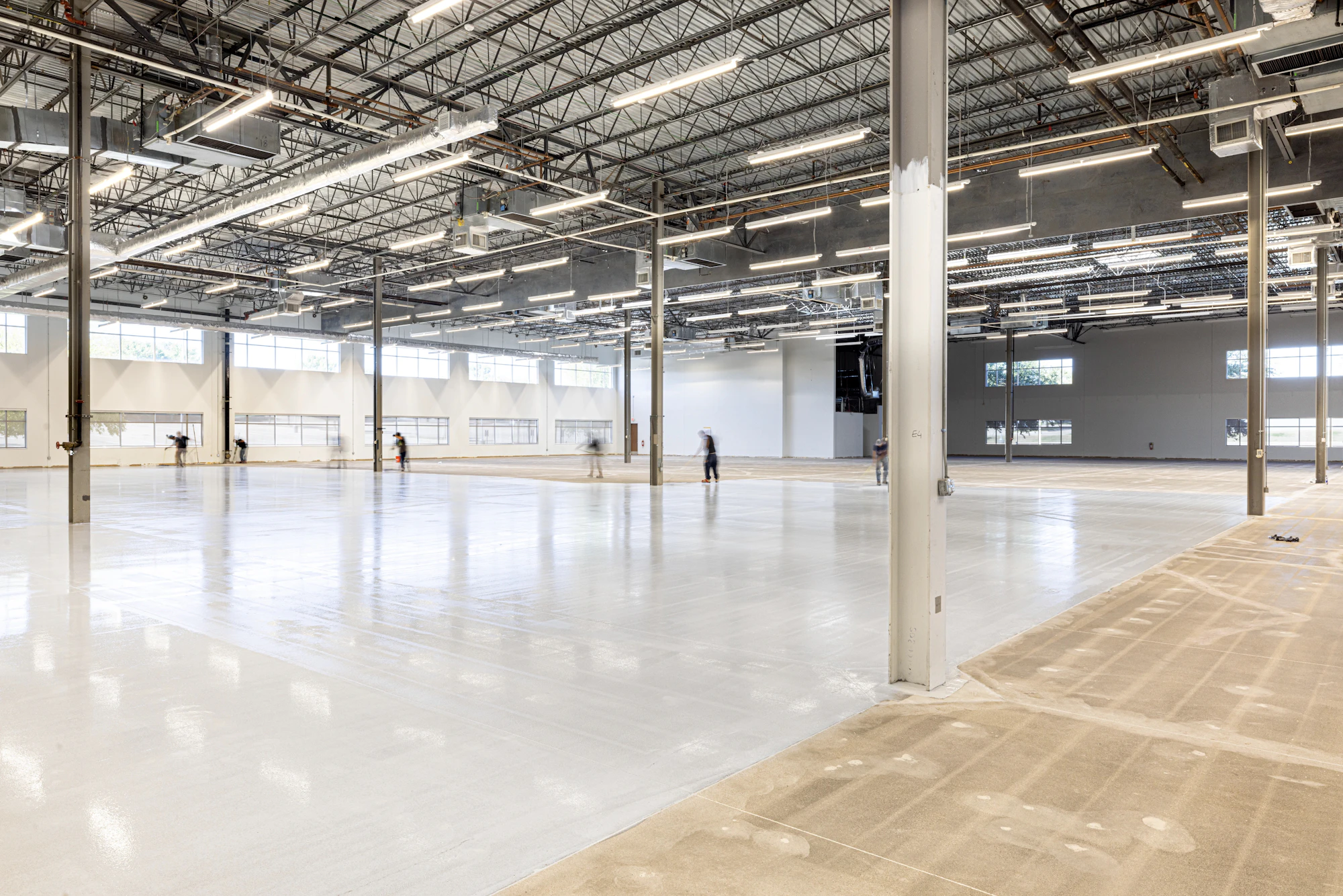 Empty modern warehouse interior with a seamless industrial floor being finished