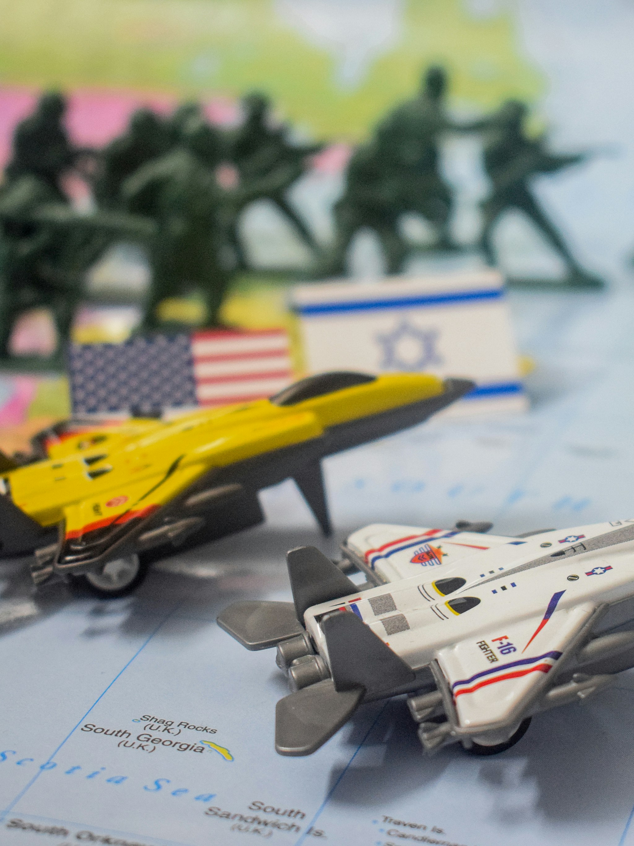 Toy soldiers, planes, and flags on a map.