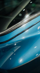 Close-up of a shiny blue car body with reflections
