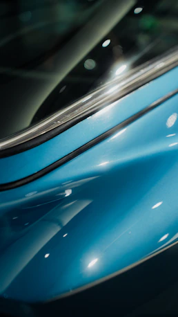 Close-up of a shiny blue car body with reflections