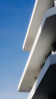 Modern white building exterior against a clear blue sky