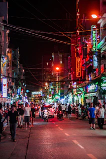 Busy street at night with neon signs and people
