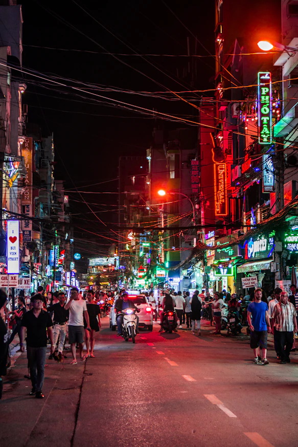 Busy street at night with neon signs and people