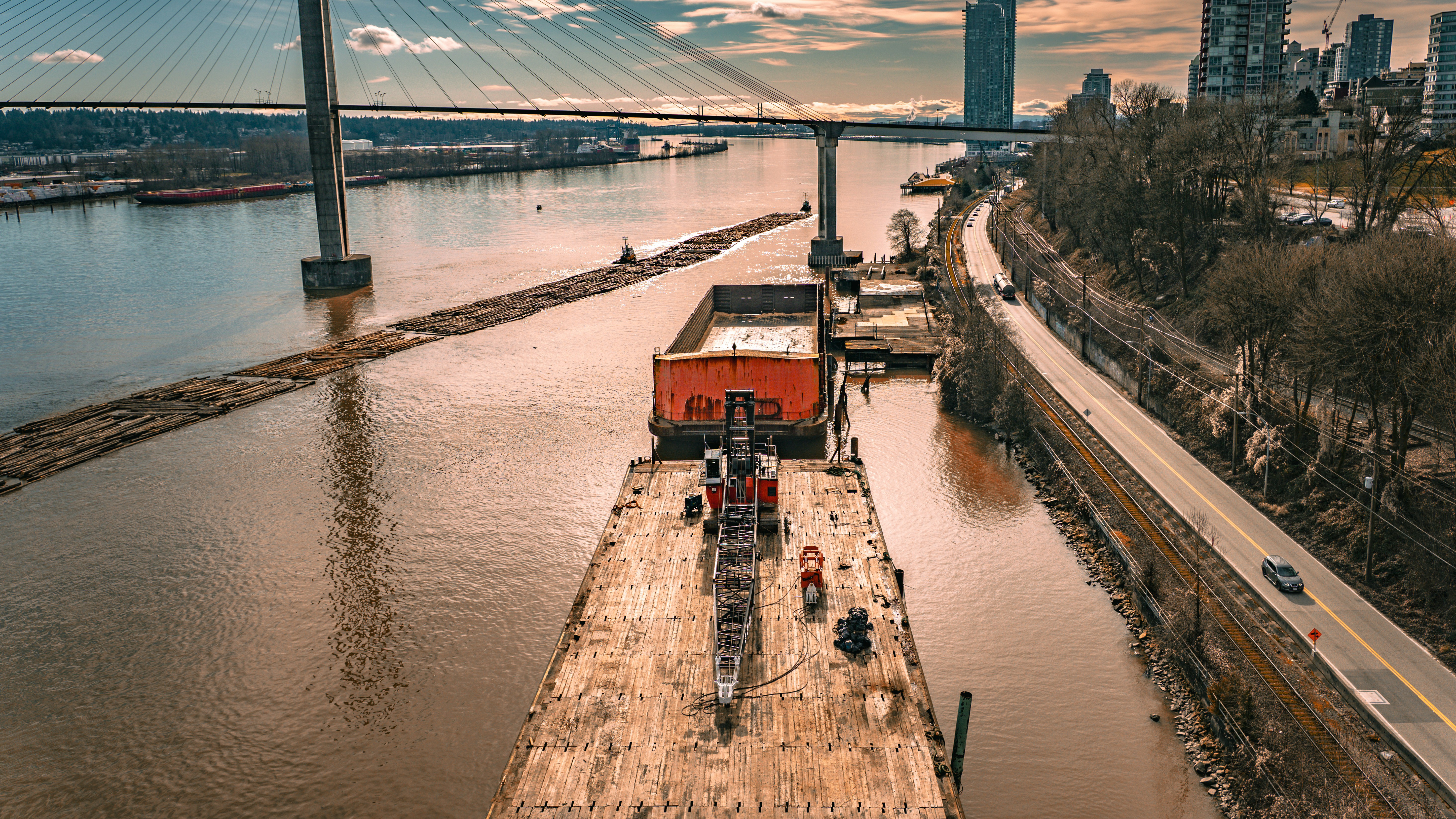 Barge with construction equipment on river near a bridge
