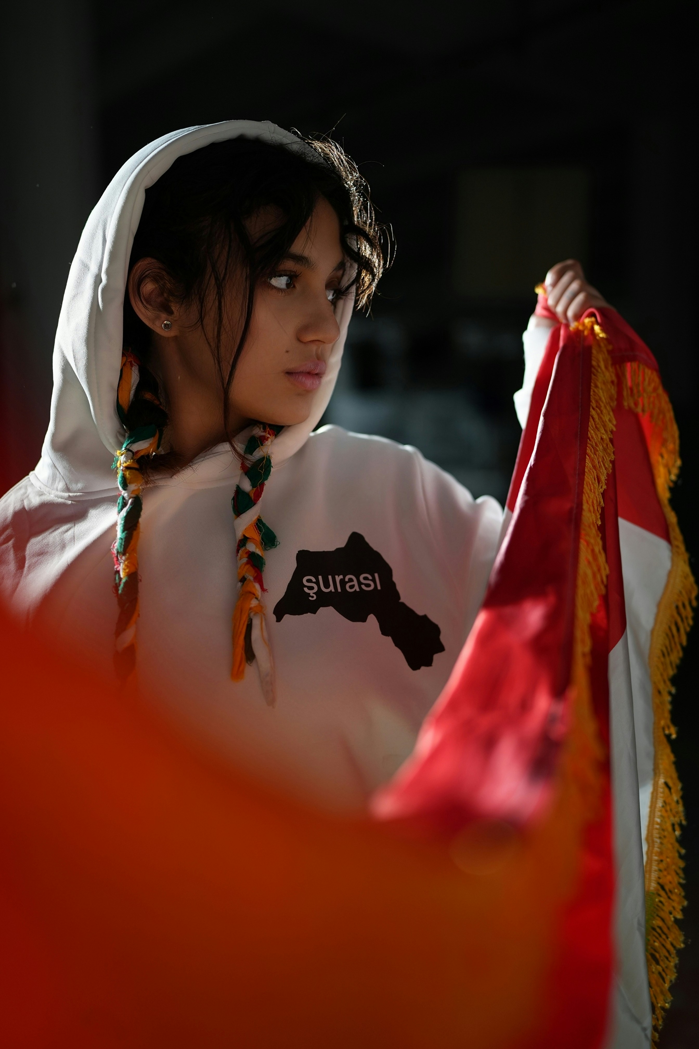Jovem mulher com moletom segurando uma bandeira