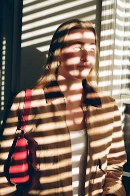 Woman in jacket with striped light pattern on face.