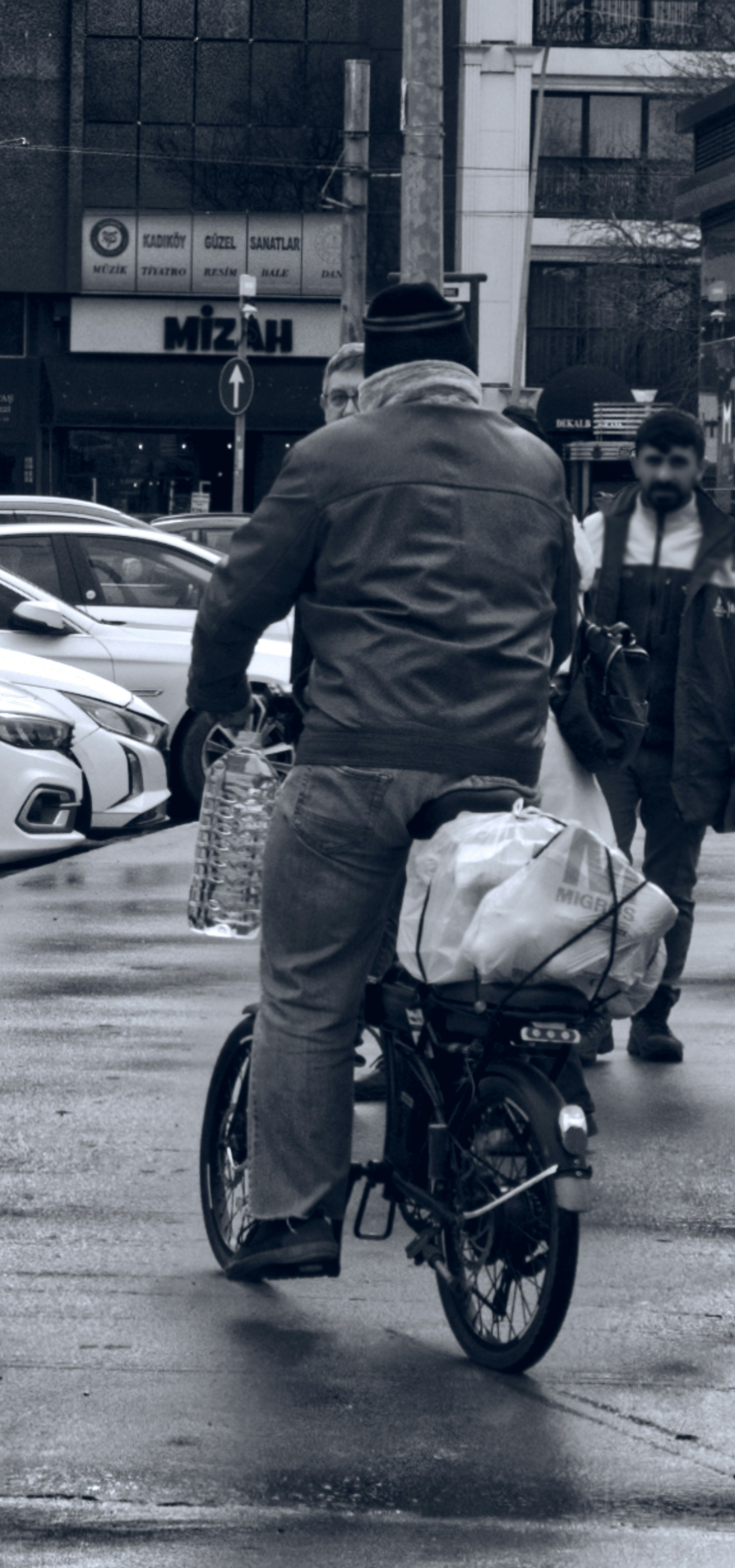 Uomo in bicicletta con la spesa in strada cittadina
