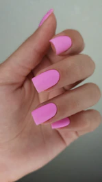 Hand with short, matte pink square nails.