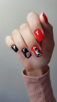 Hand with black and red nails featuring anime characters.