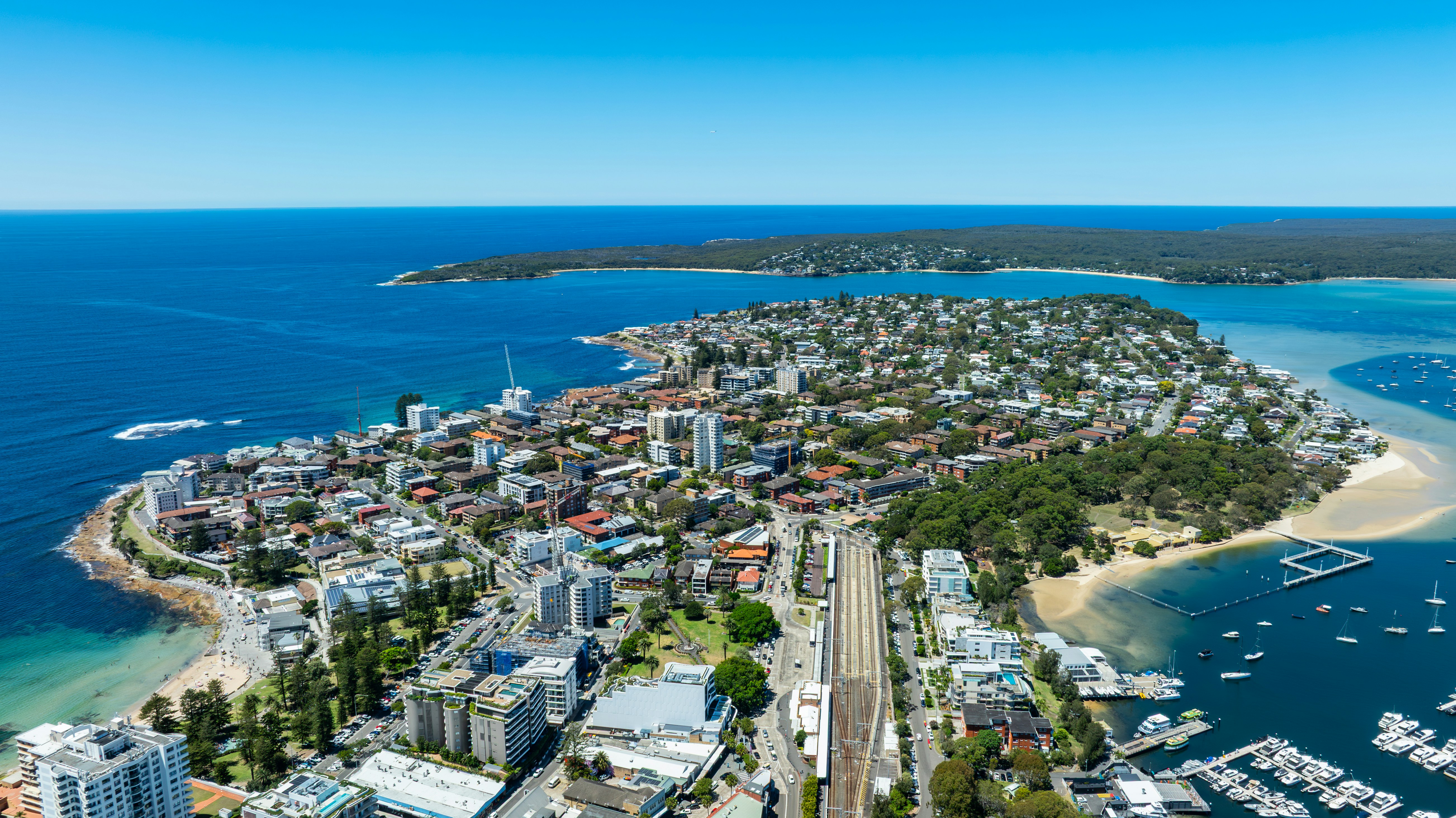 Aerial view of a coastal city with boats and ocean.