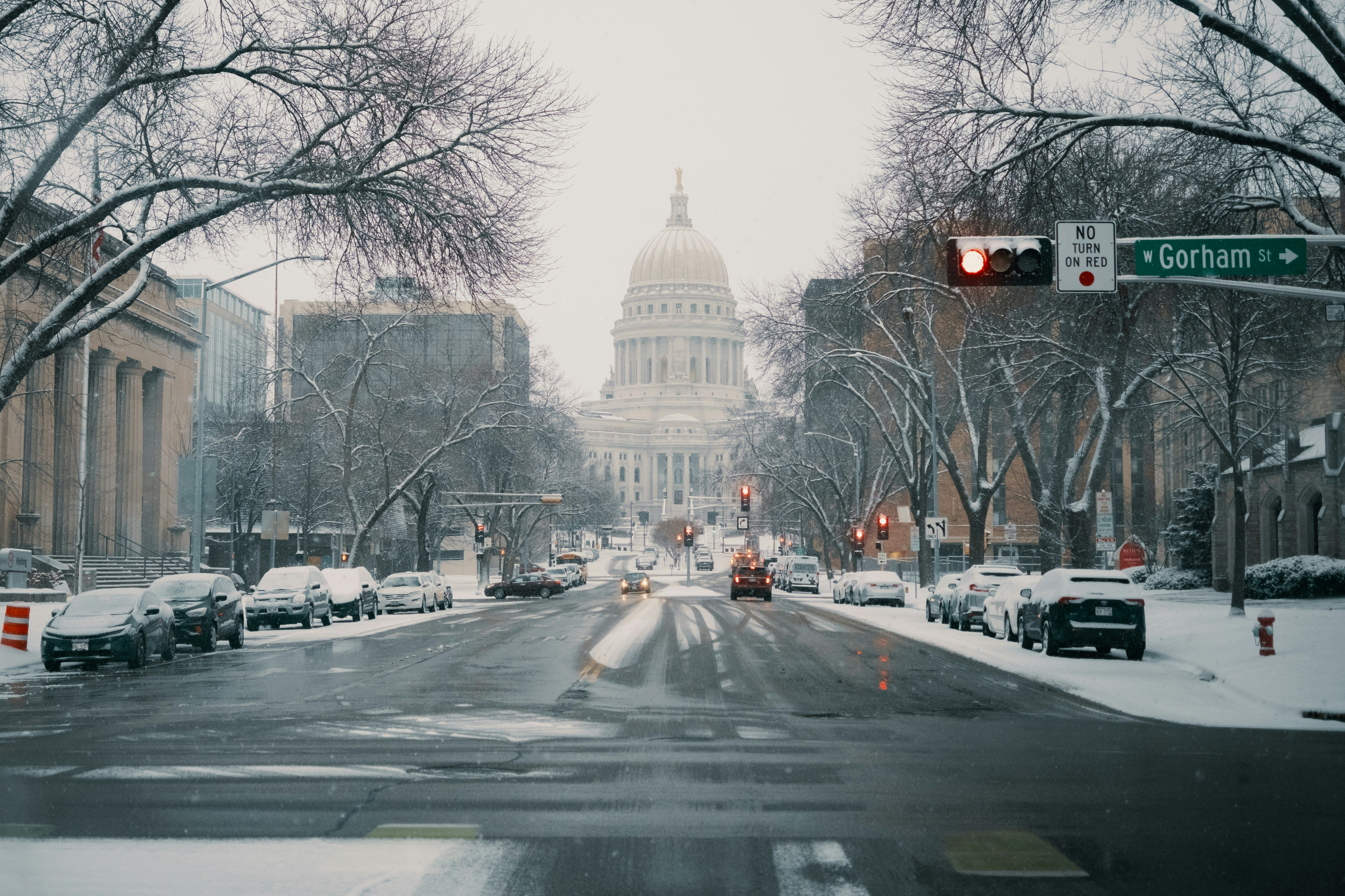 Snowy street leading to a domed building.