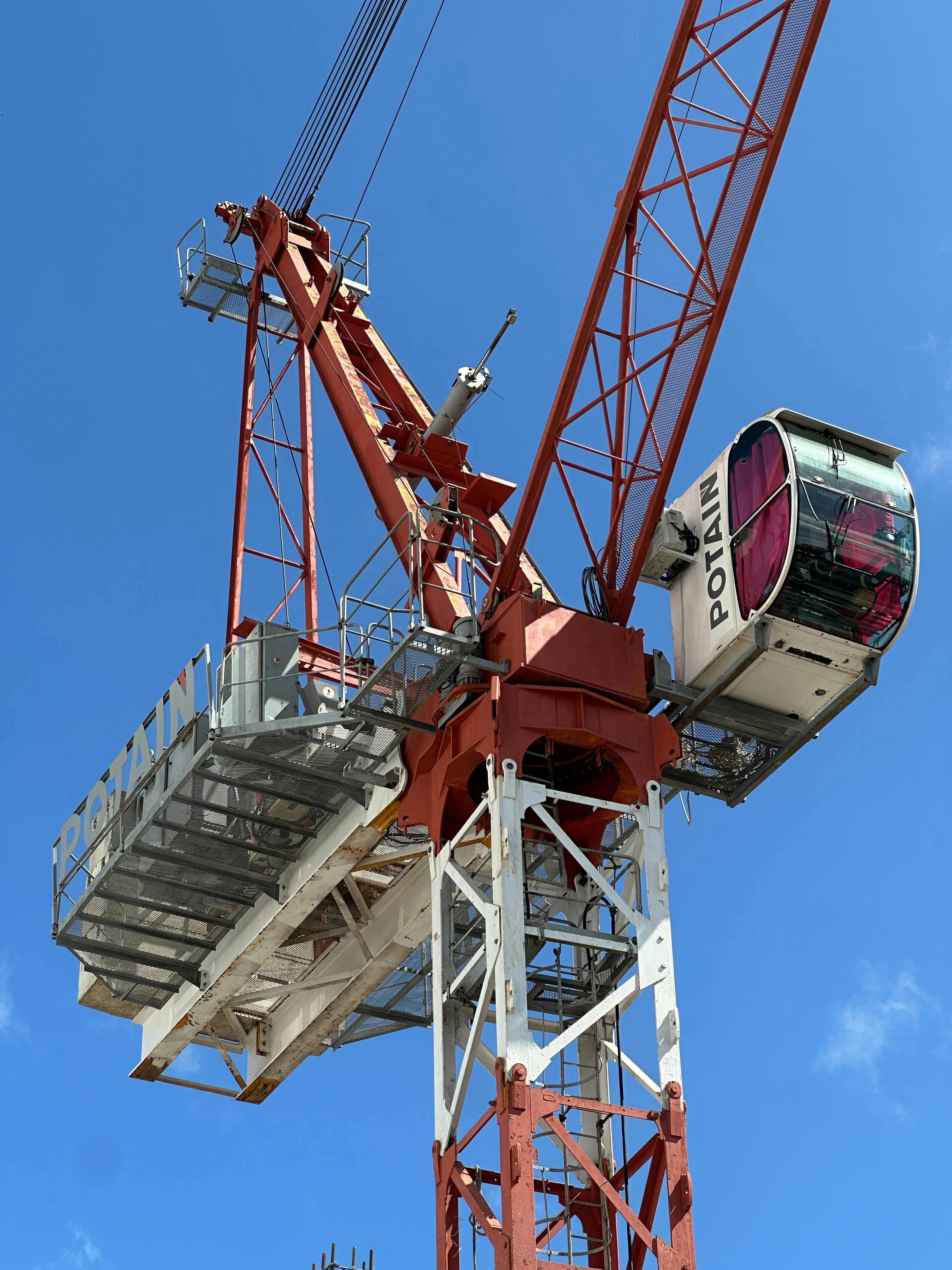 A tall construction crane against a clear blue sky