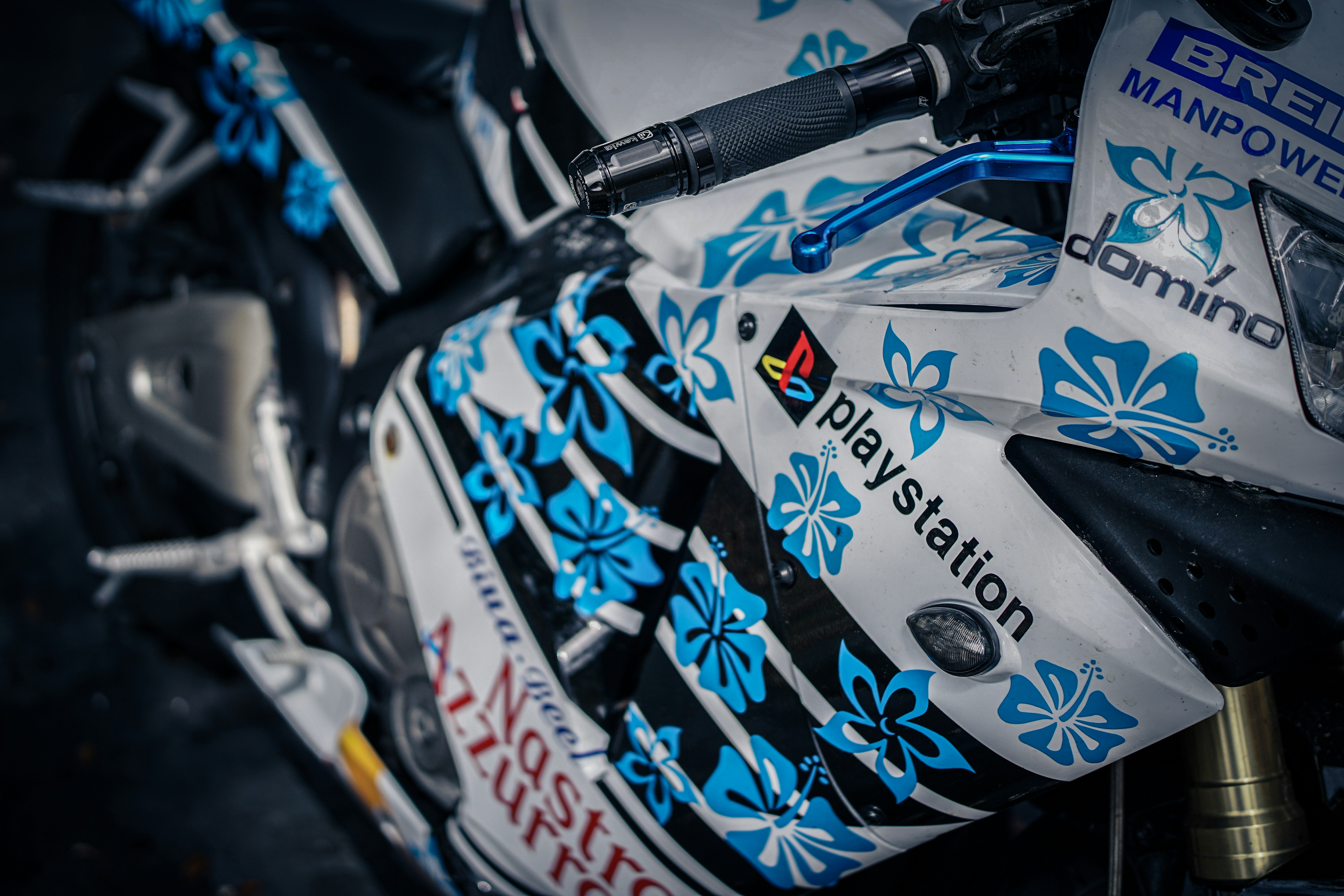 A motorcycle with blue floral decals and playstation logo.