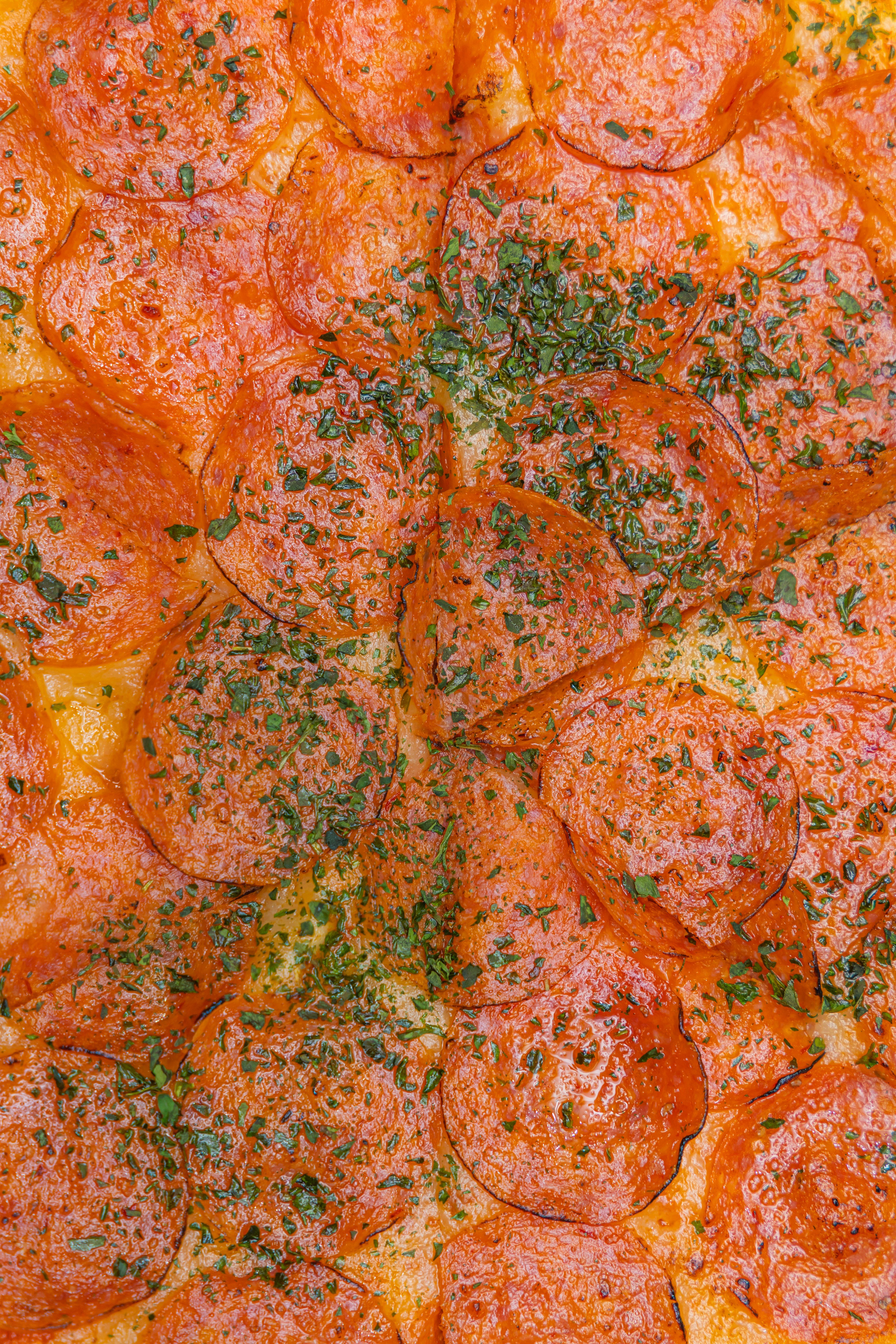 Primer plano de una pizza de pepperoni con perejil