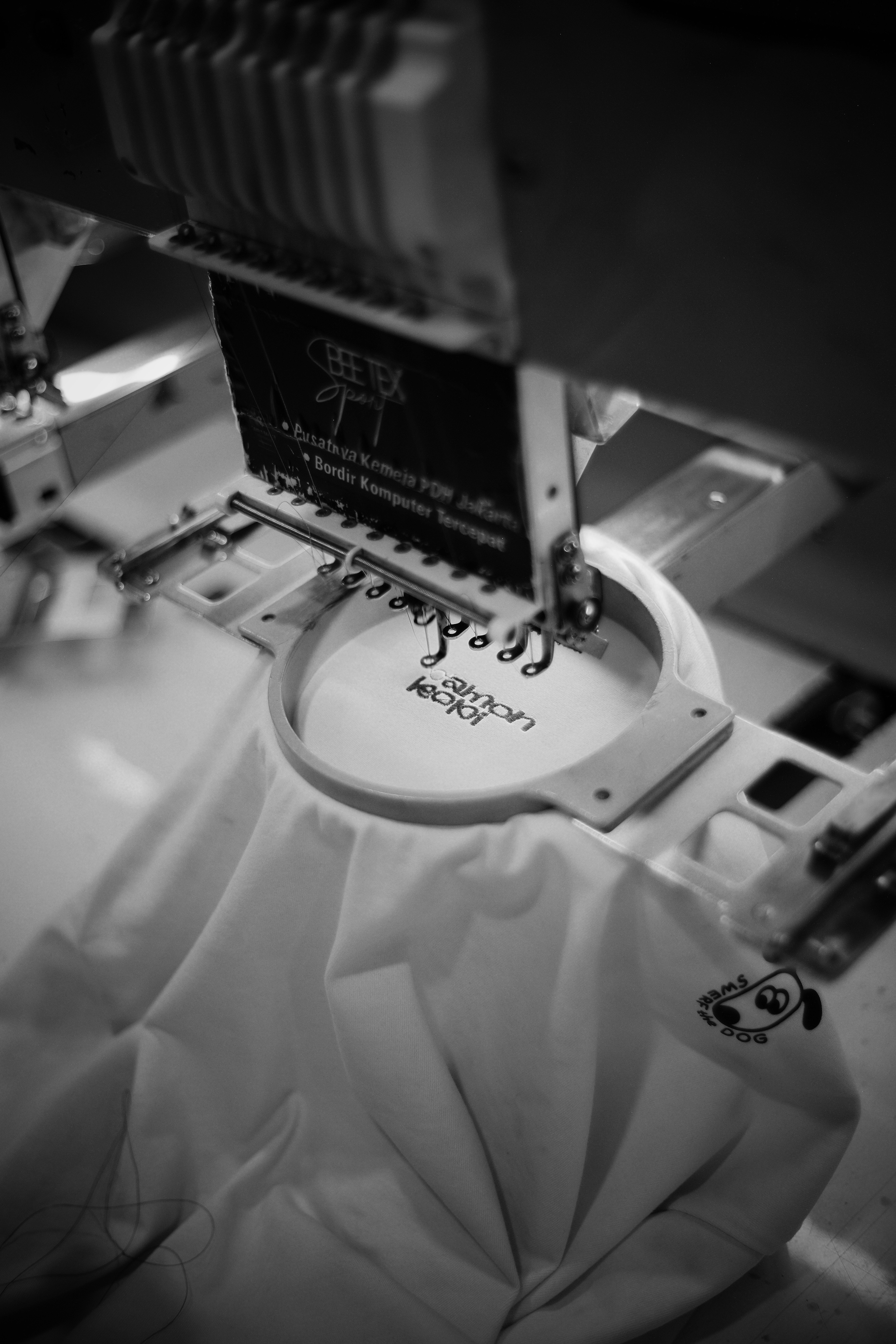 Embroidery machine stitching logo onto white fabric
