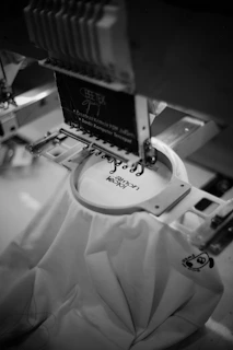 Embroidery machine stitching logo onto white fabric