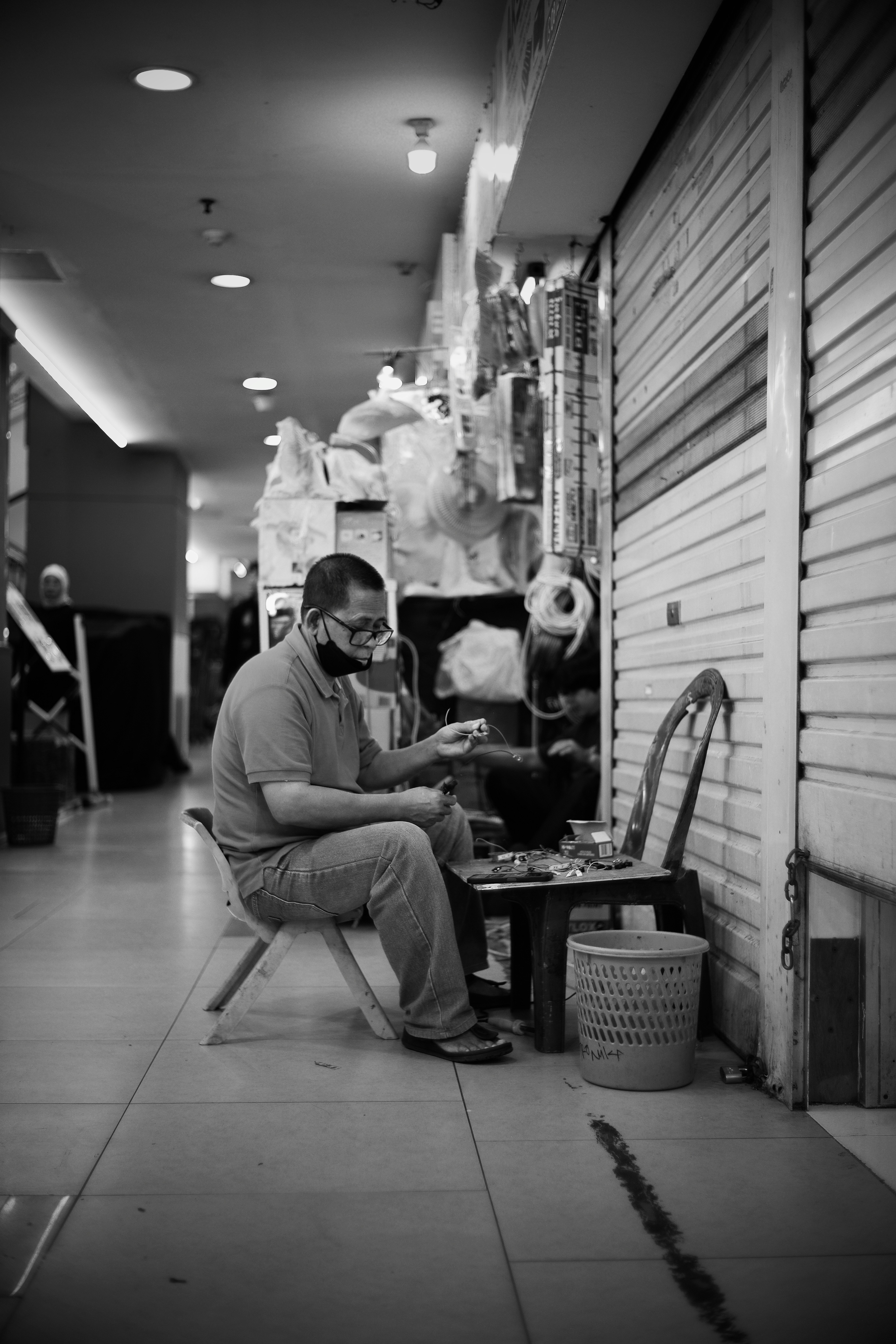 Homem sentado em um corredor, olhando para algo