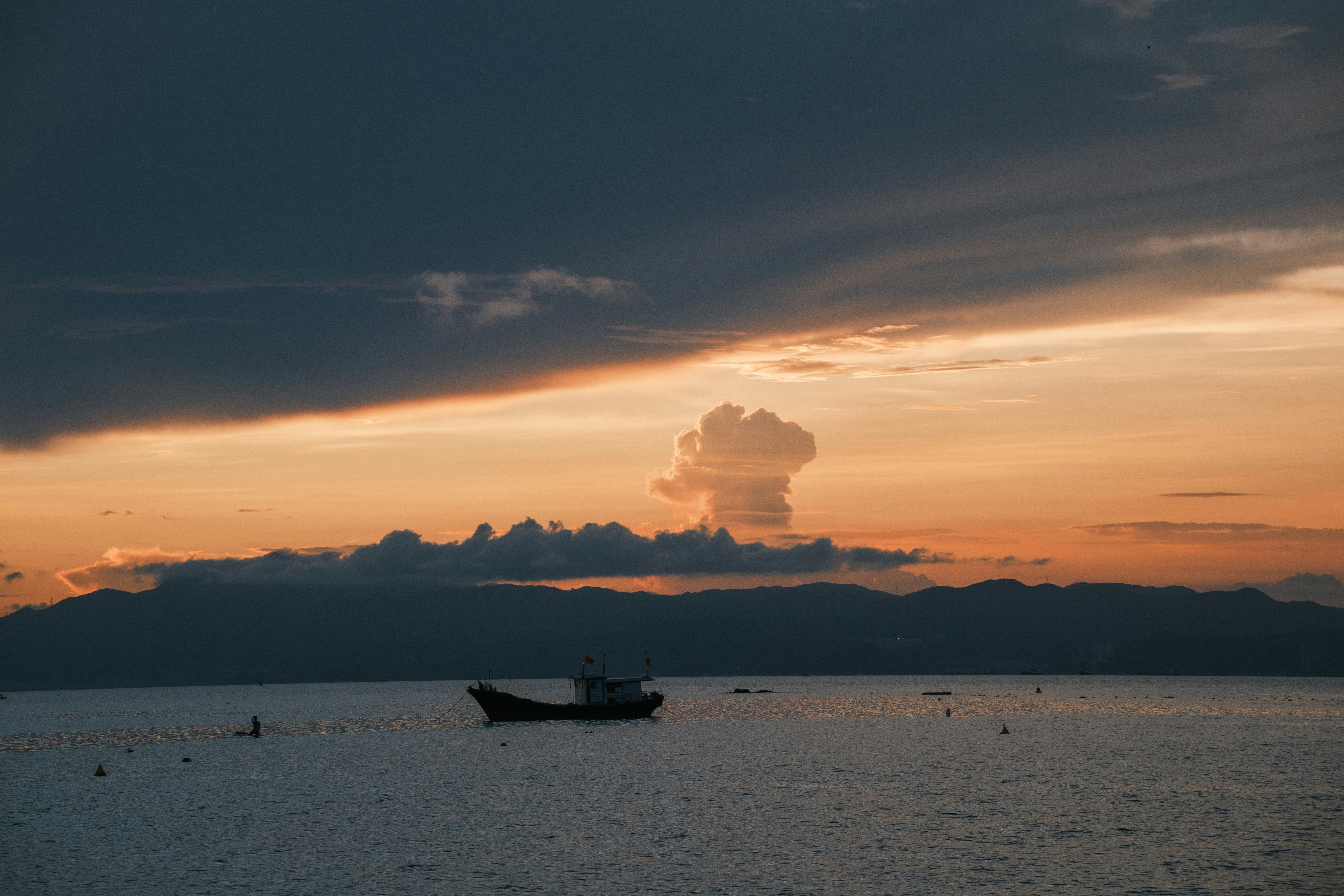 夕暮れの水面に一匹の船が浮かぶ