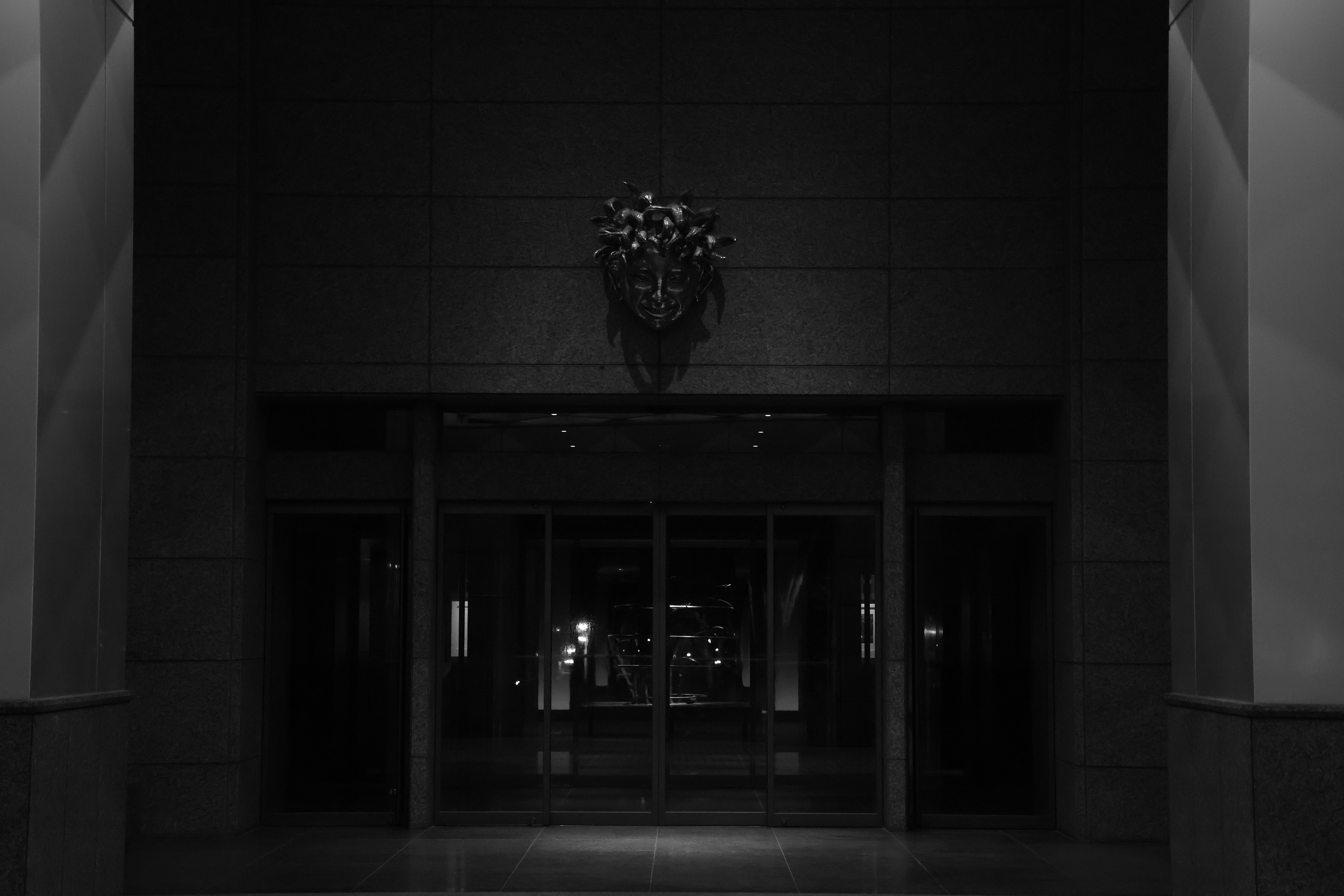 Dark entrance with glass doors and overhead decoration