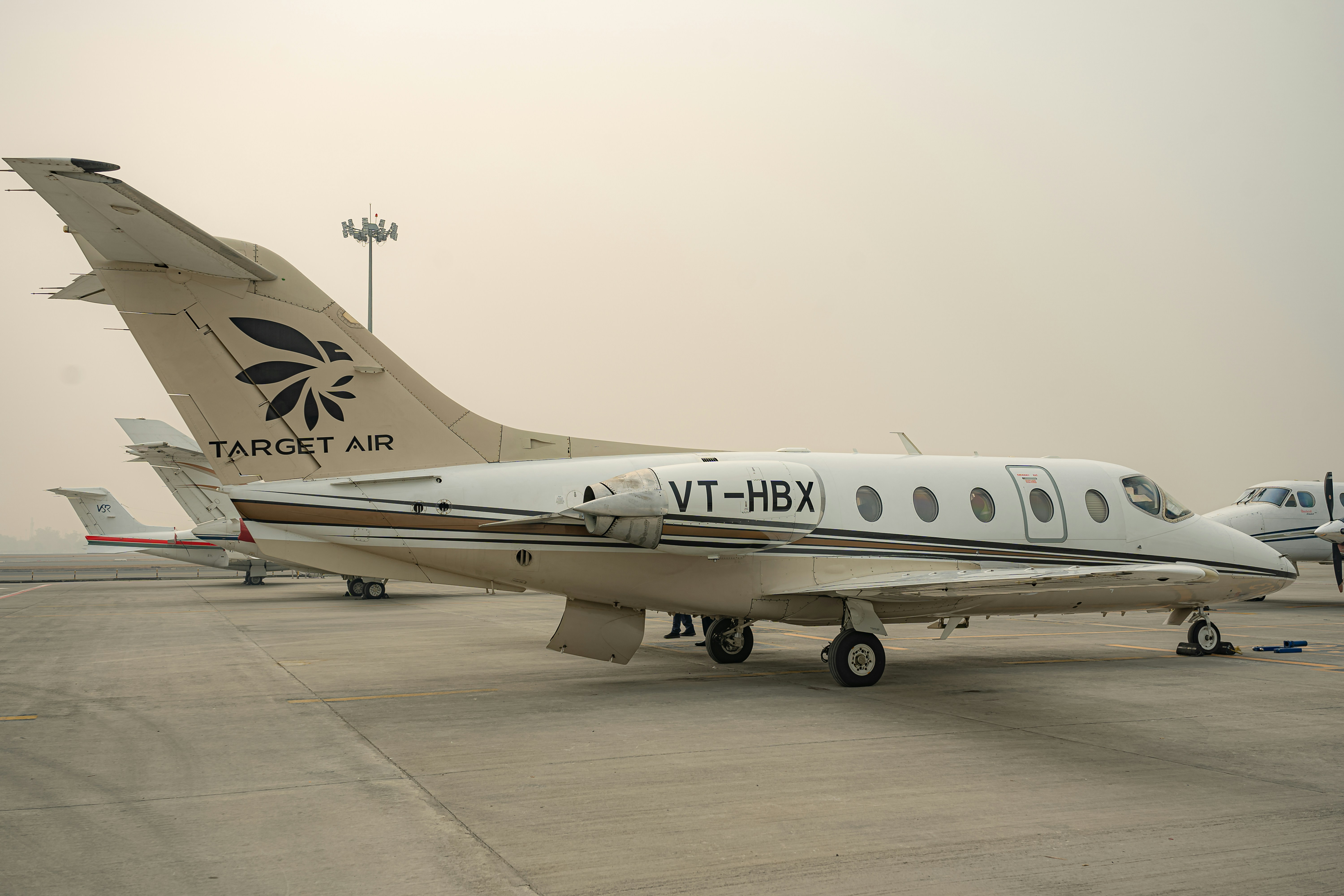 A private jet parked on an airport tarmac.