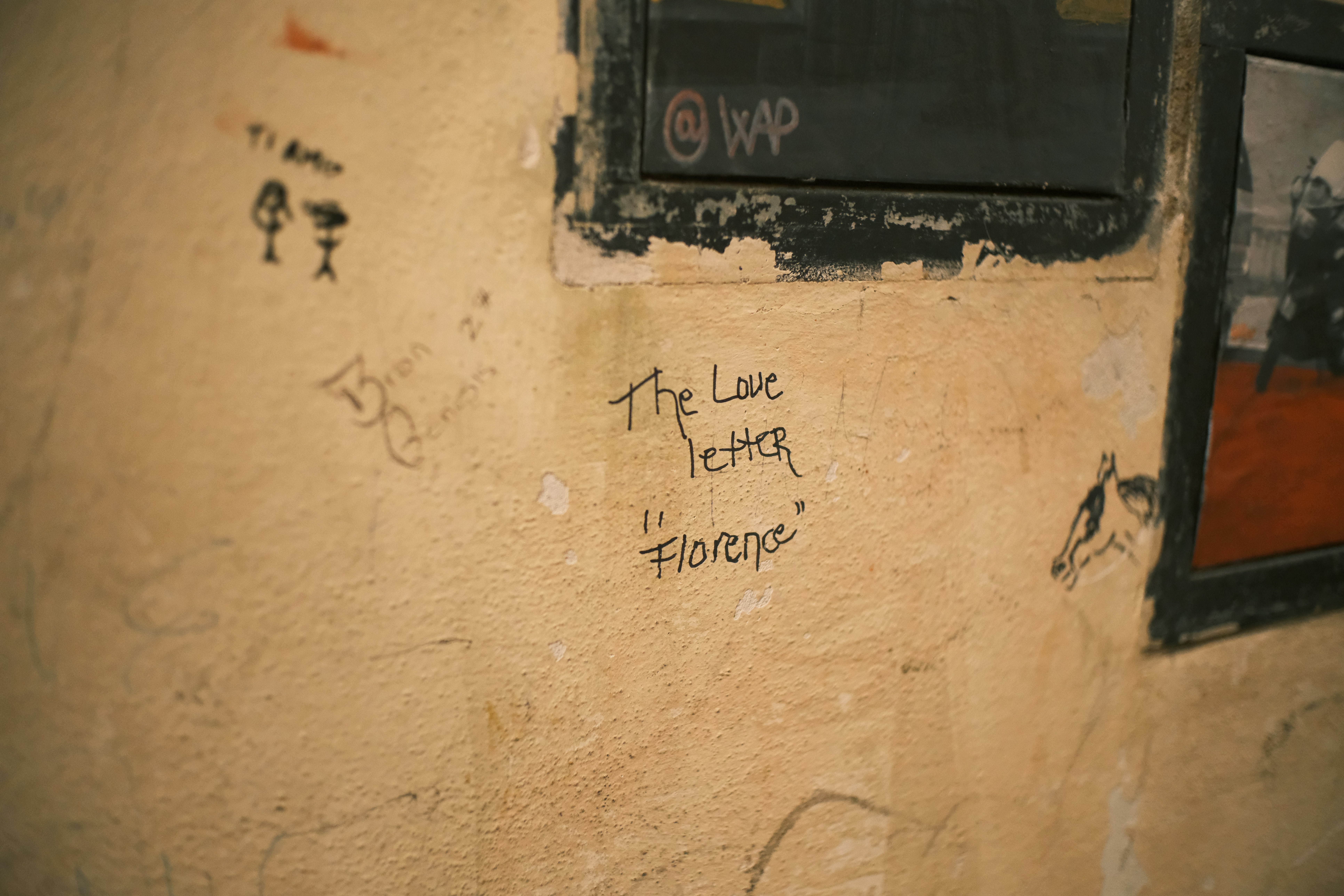 Graffiti on a textured wall with a window.