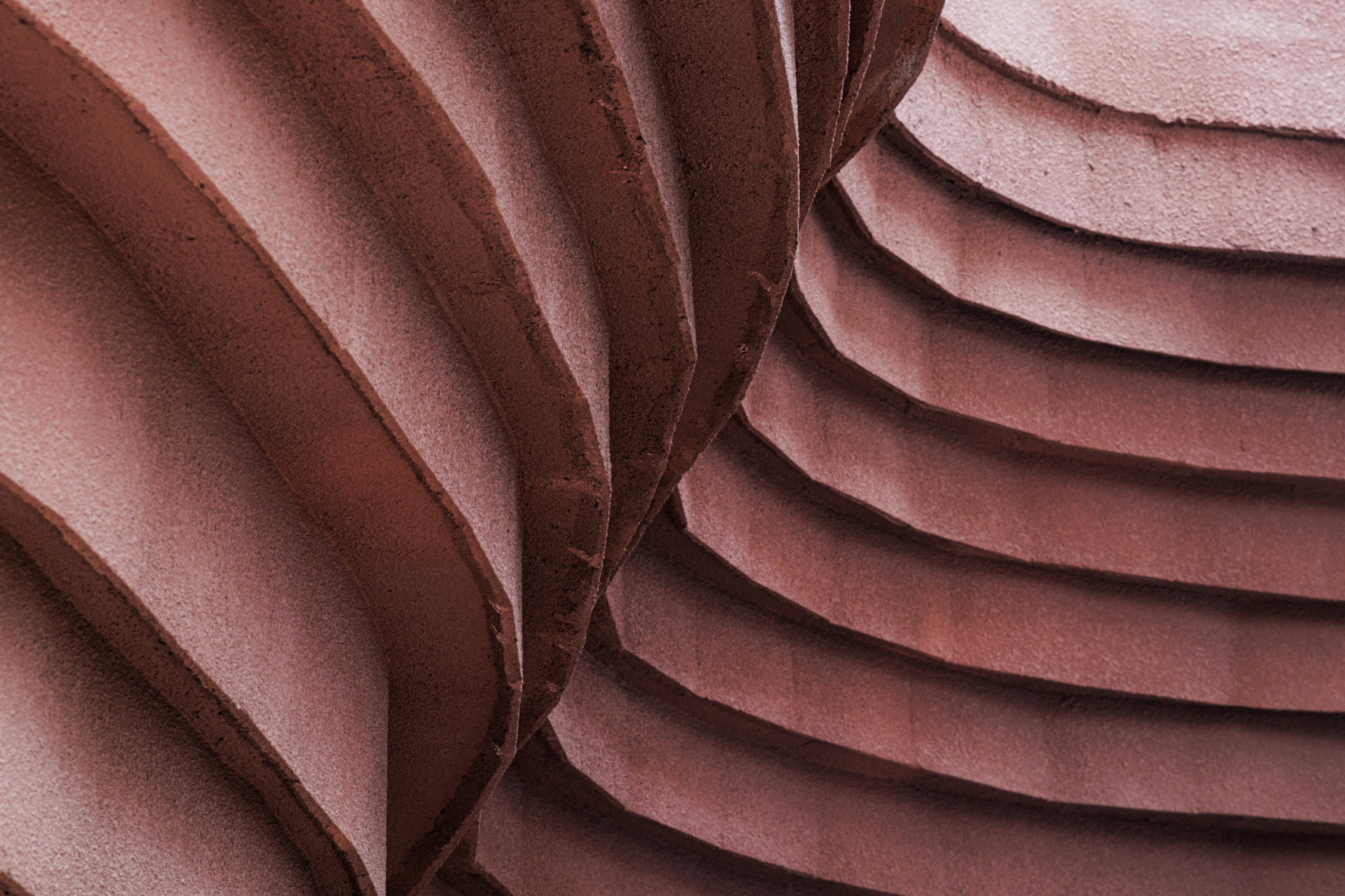 Close-up de formas abstratas marrom-avermelhadas em camadas, texturizadas.