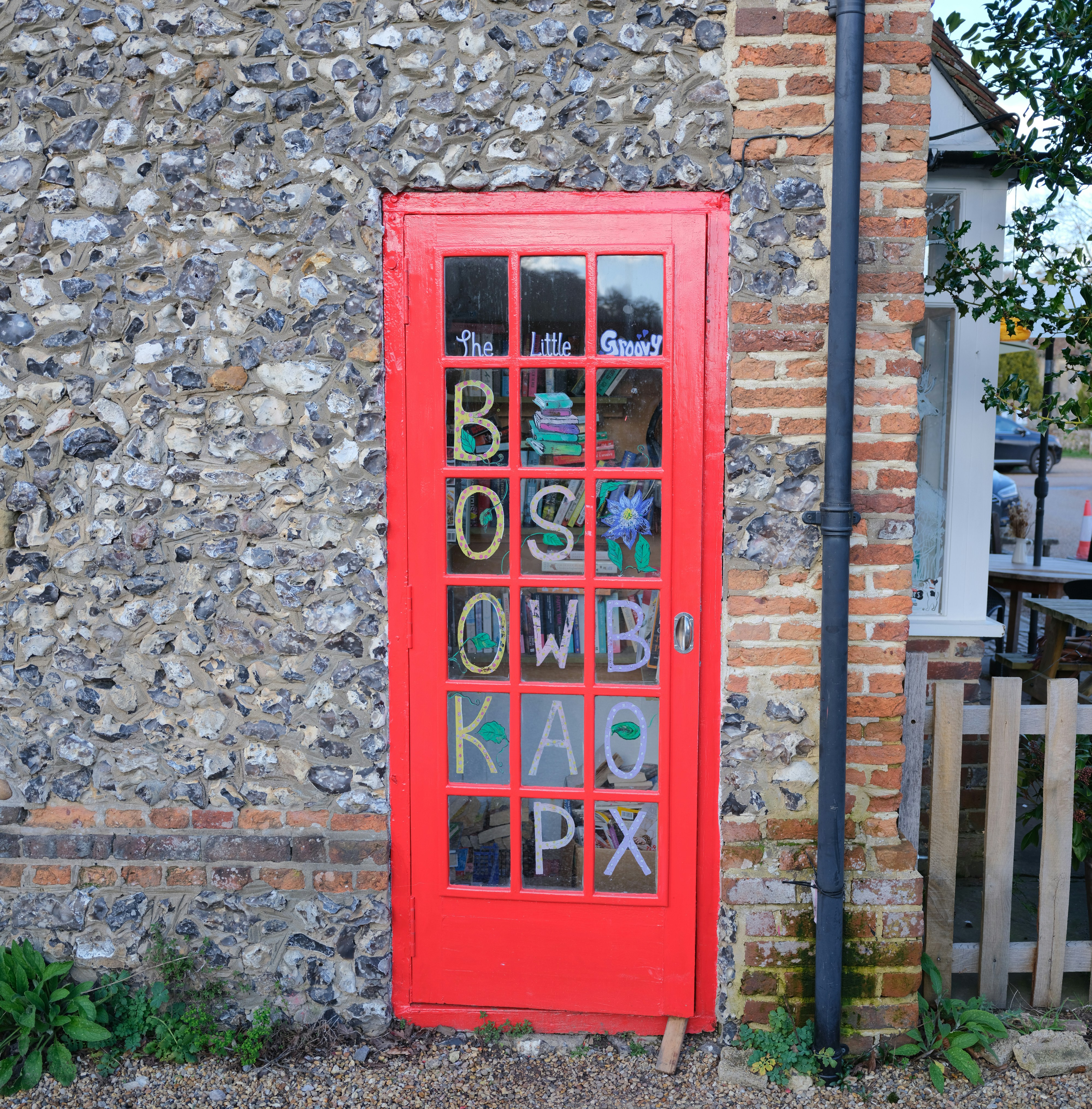 Red door with books and letters visible inside