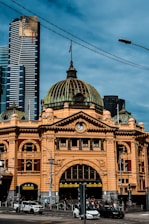 Historic yellow building with modern skyscrapers behind