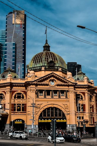 Historic yellow building with modern skyscrapers behind