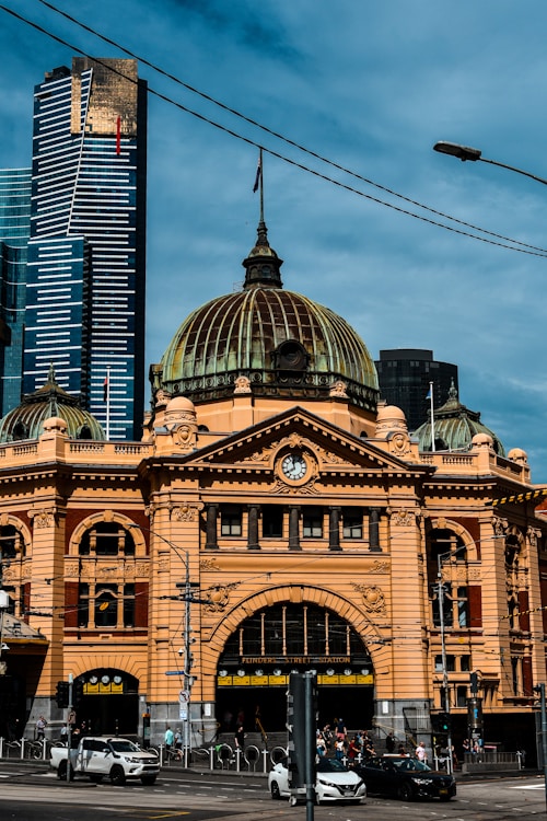 Historic yellow building with modern skyscrapers behind