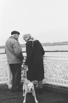 Elderly couple with dog on a pier
