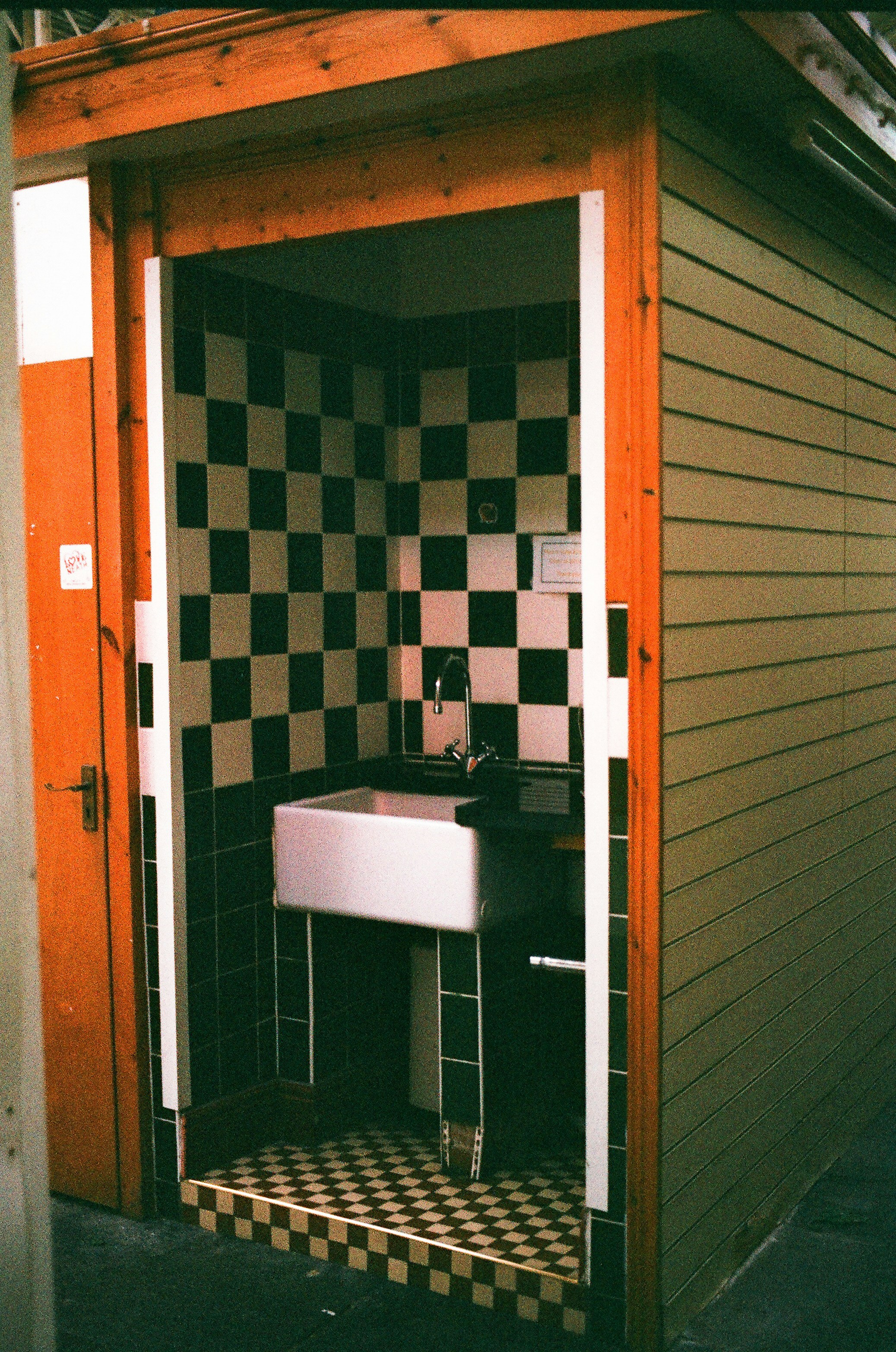 Una piccola stanza con lavandino e piastrelle a scacchi