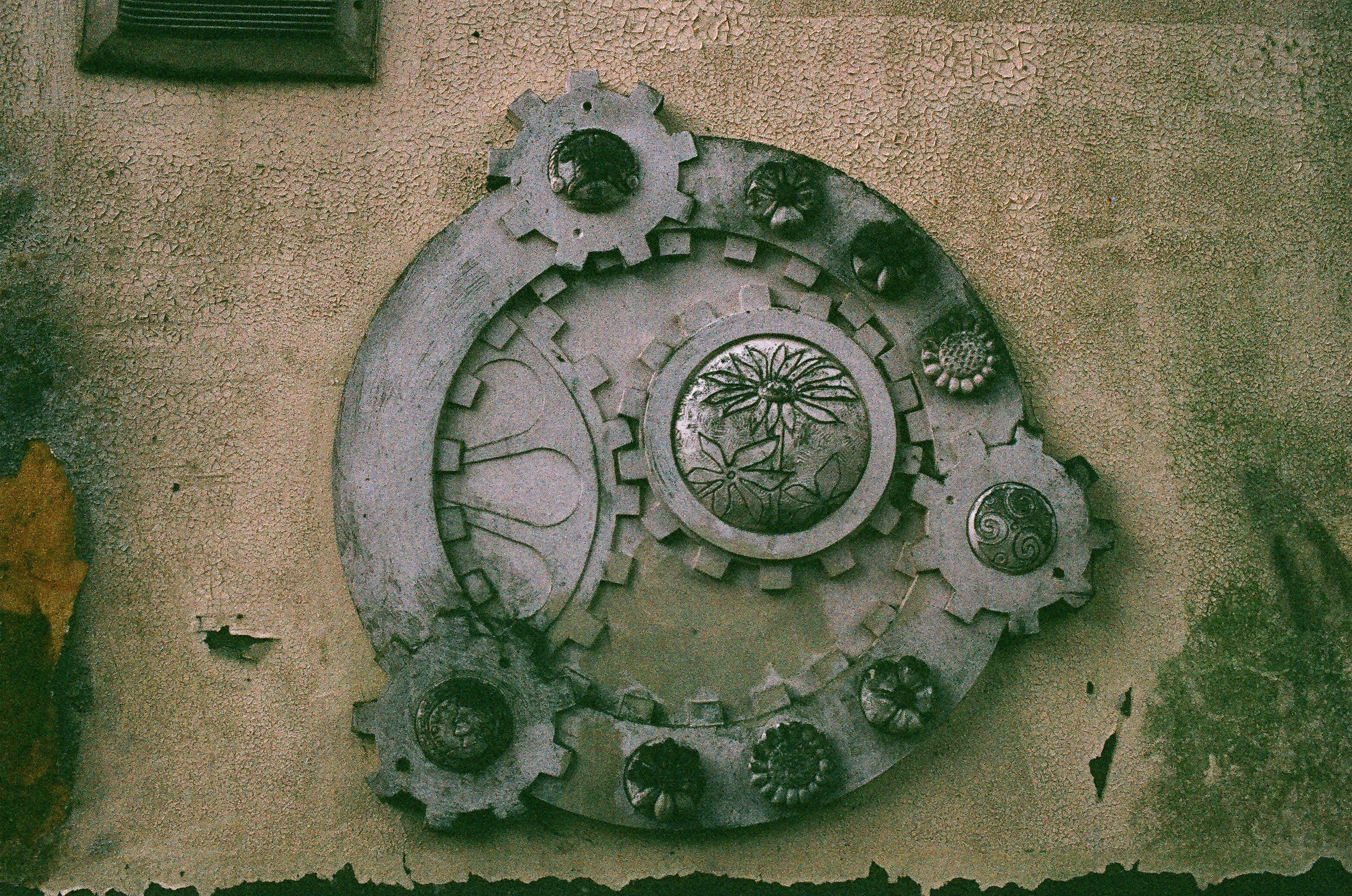 Decoração ornamentada de engrenagens metálicas em uma parede texturizada
