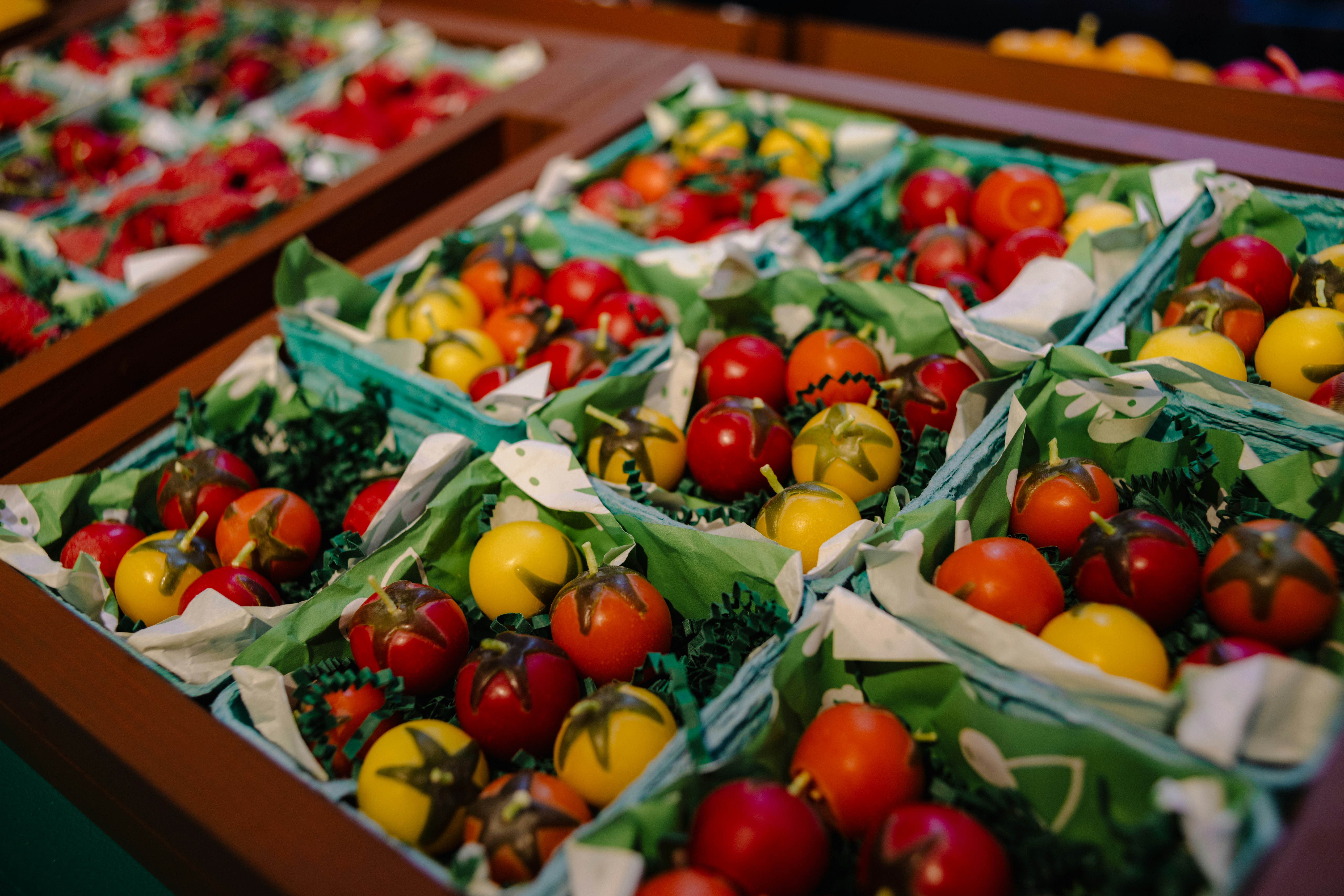 Assortment of colorful cherry tomatoes in green packaging.