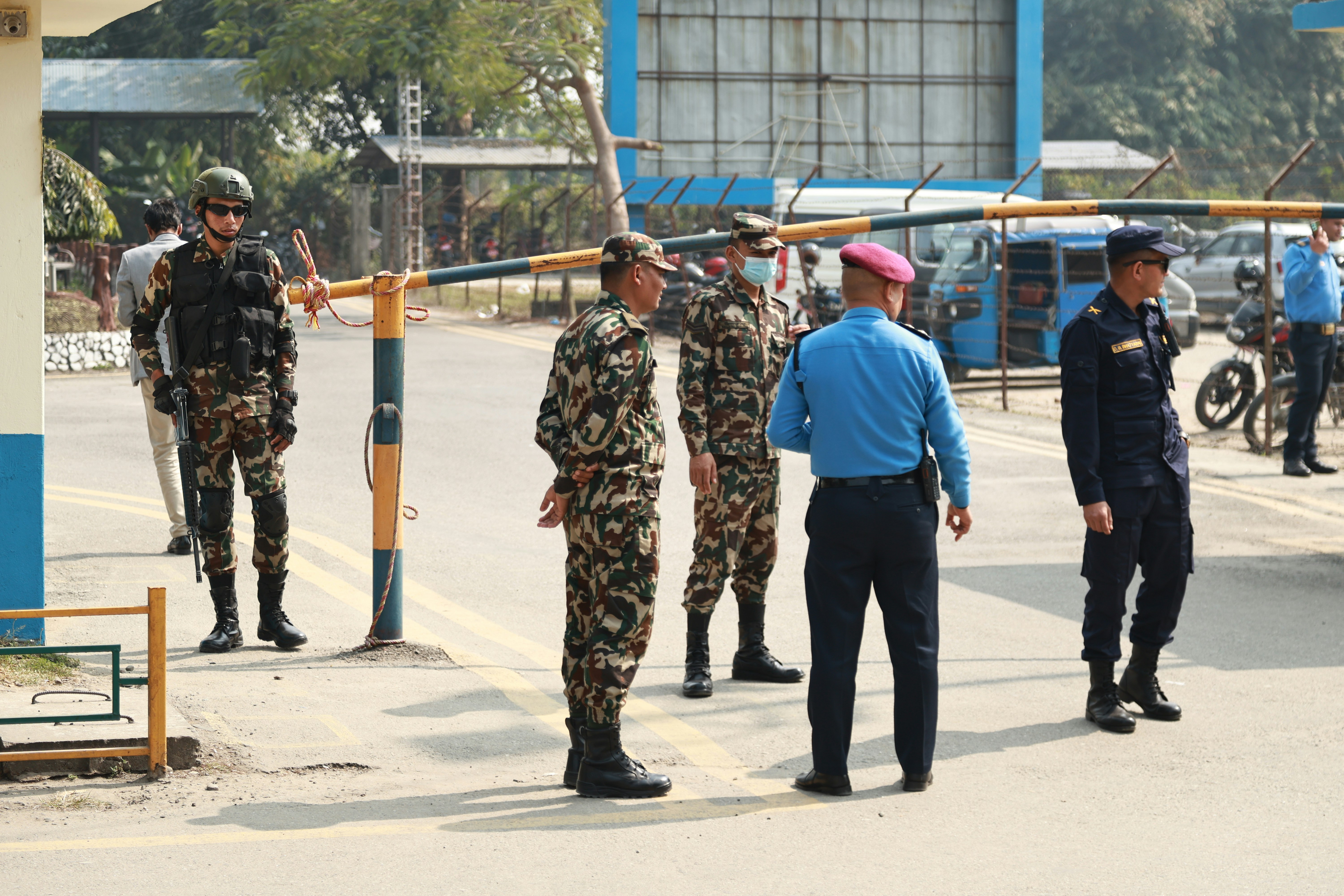 एक पुलिस अधिकारी क्राइम सीन पर जांच करते हुए, आसपास डरे हुए ग्रामीण खड़े हैं