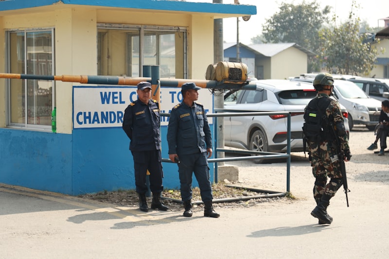Two police officers and a soldier stand guard at entrance.
