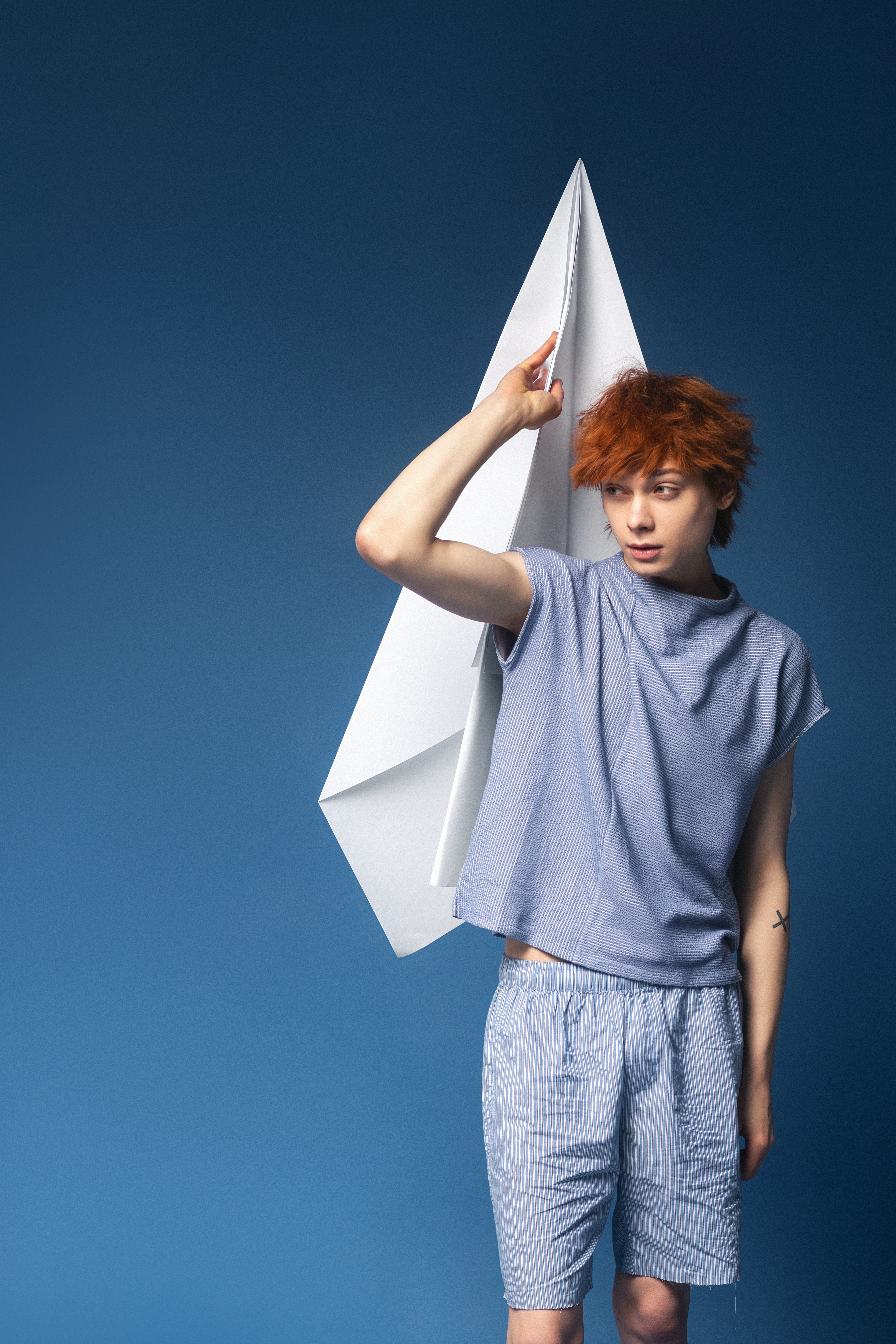 Young person holding a large paper airplane