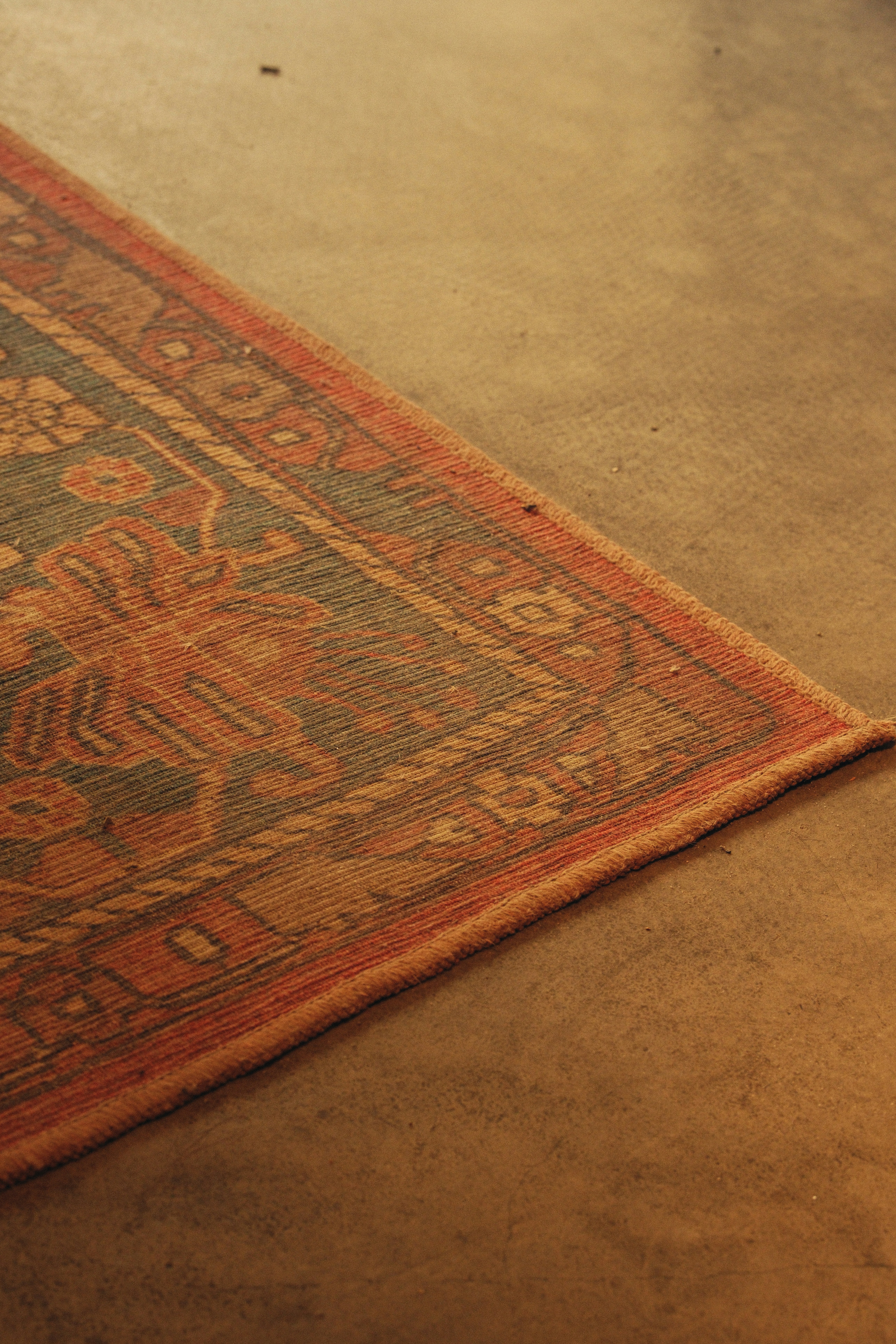 Close-up of a patterned rug on a concrete floor