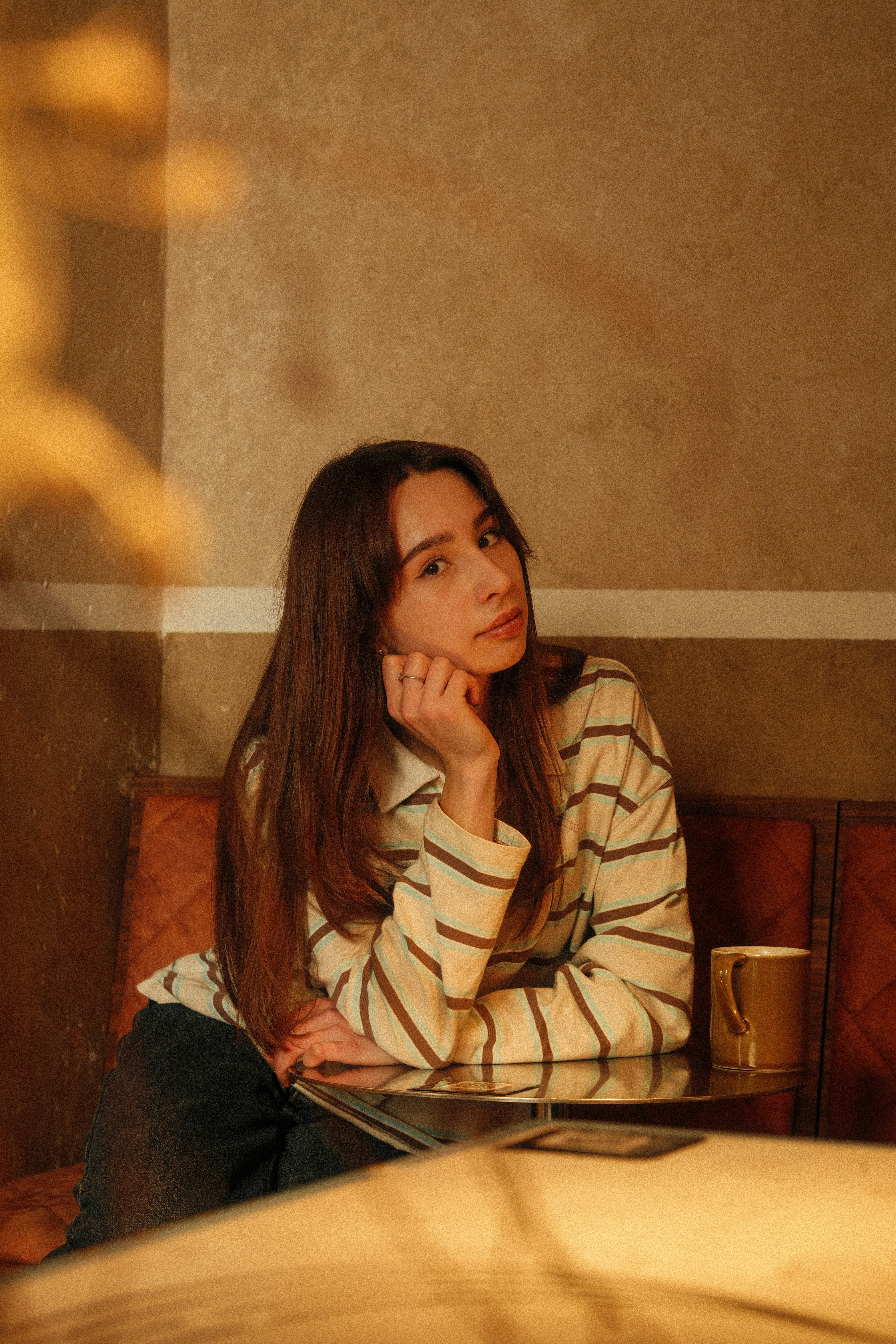 Young woman sitting at a table with a cup.
