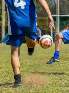 Soccer player kicking a ball on a grassy field